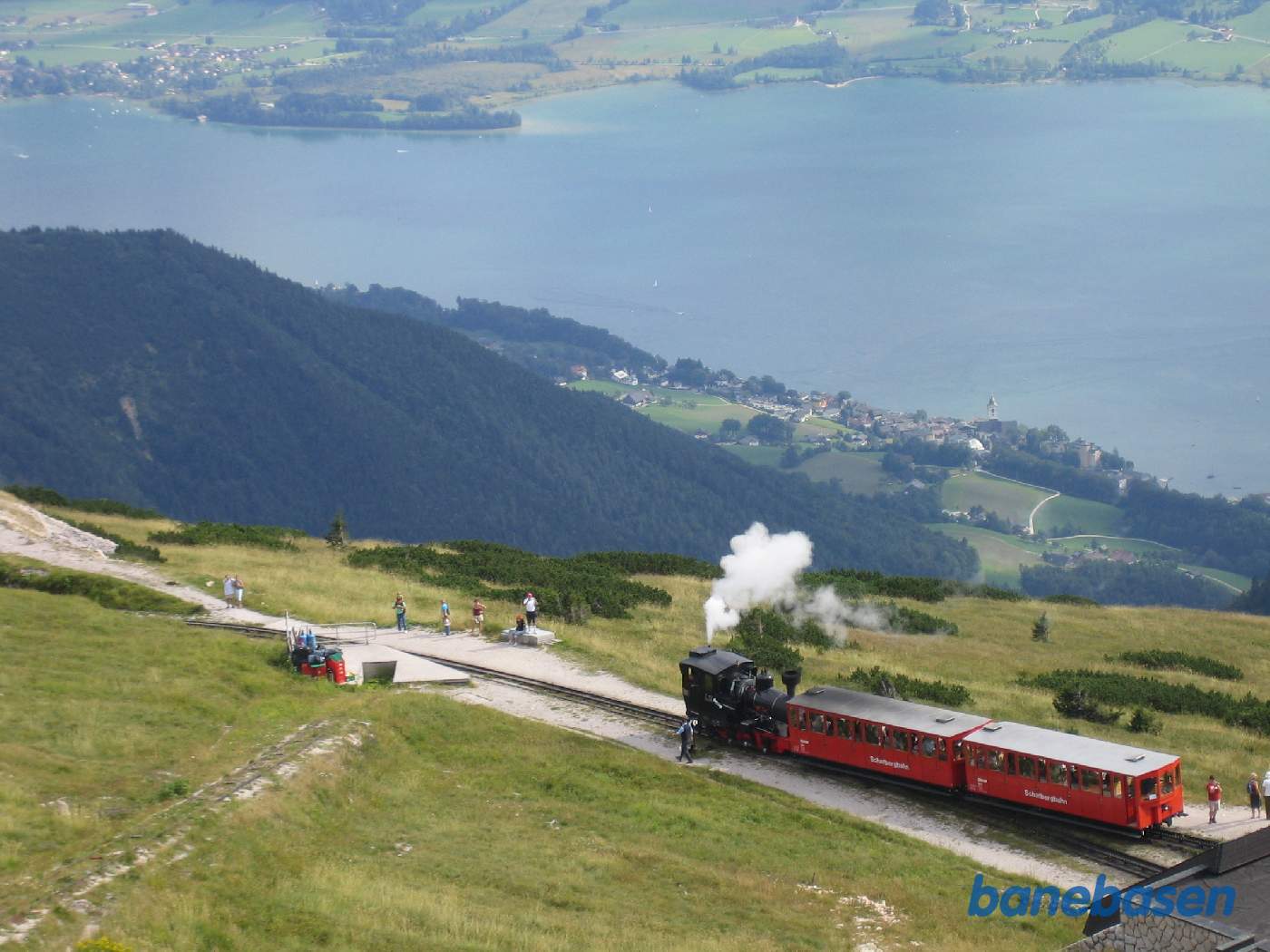 Et fyldt persontog på vej ned til byen ved søen