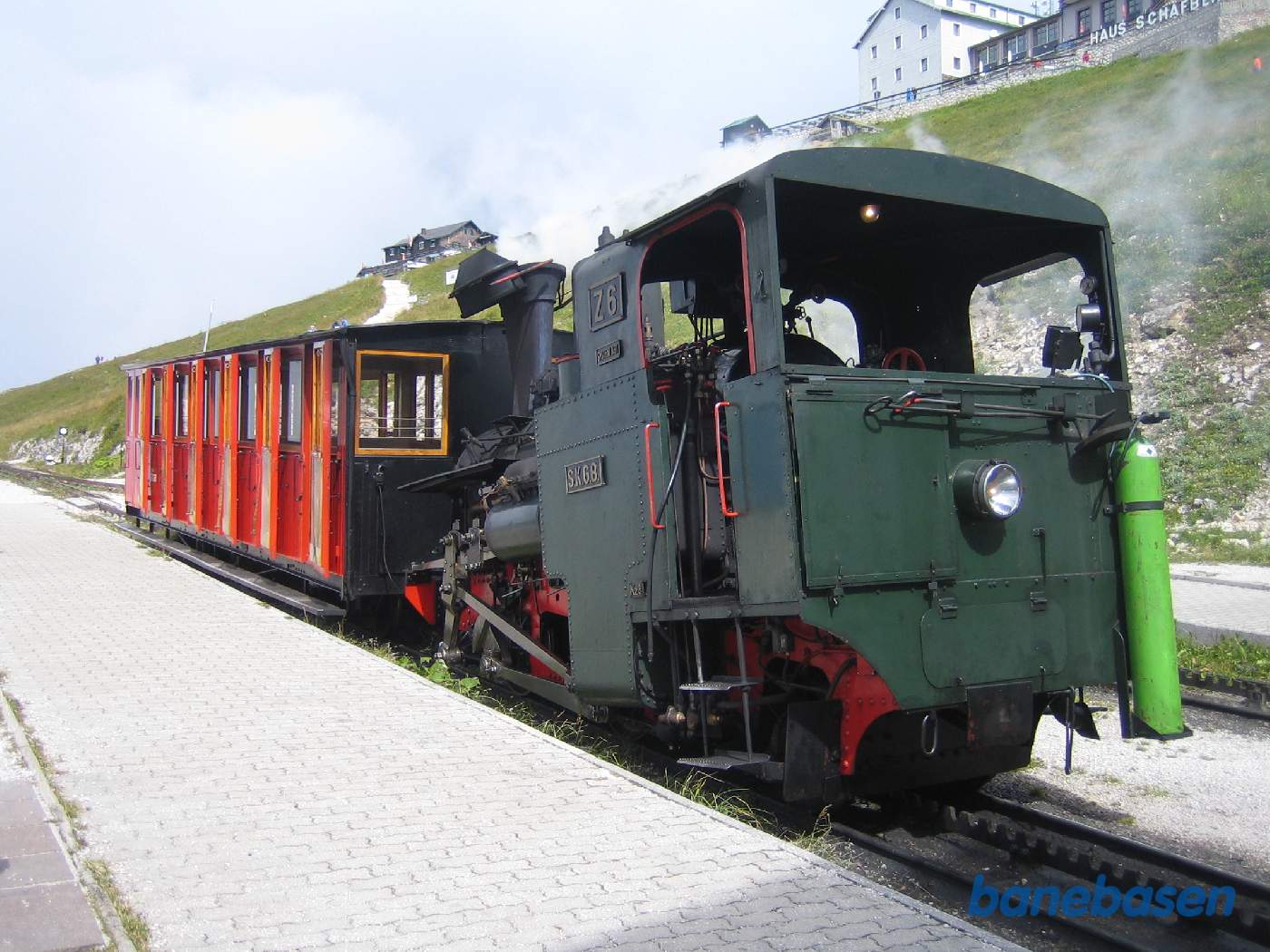 Damplokomotiv og personvogn ved perron