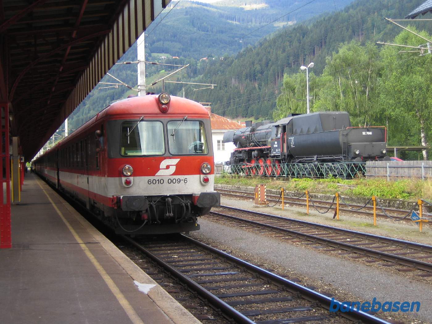 Persontog ved perron, damplokomotiv på sporramme til højre