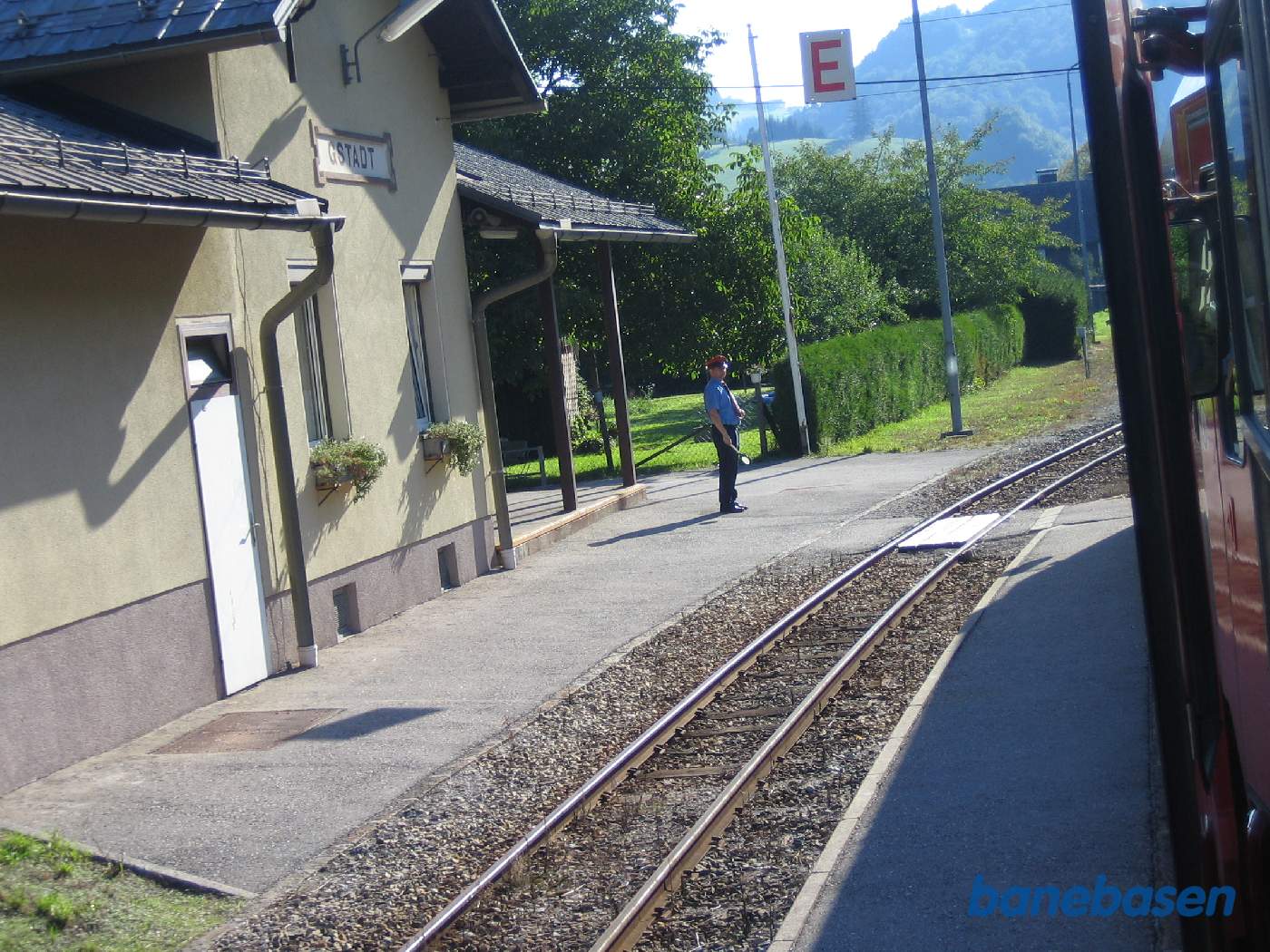 Stationsbygningen set fra banesiden, stationsforstanderen klar til at give afgangstegn