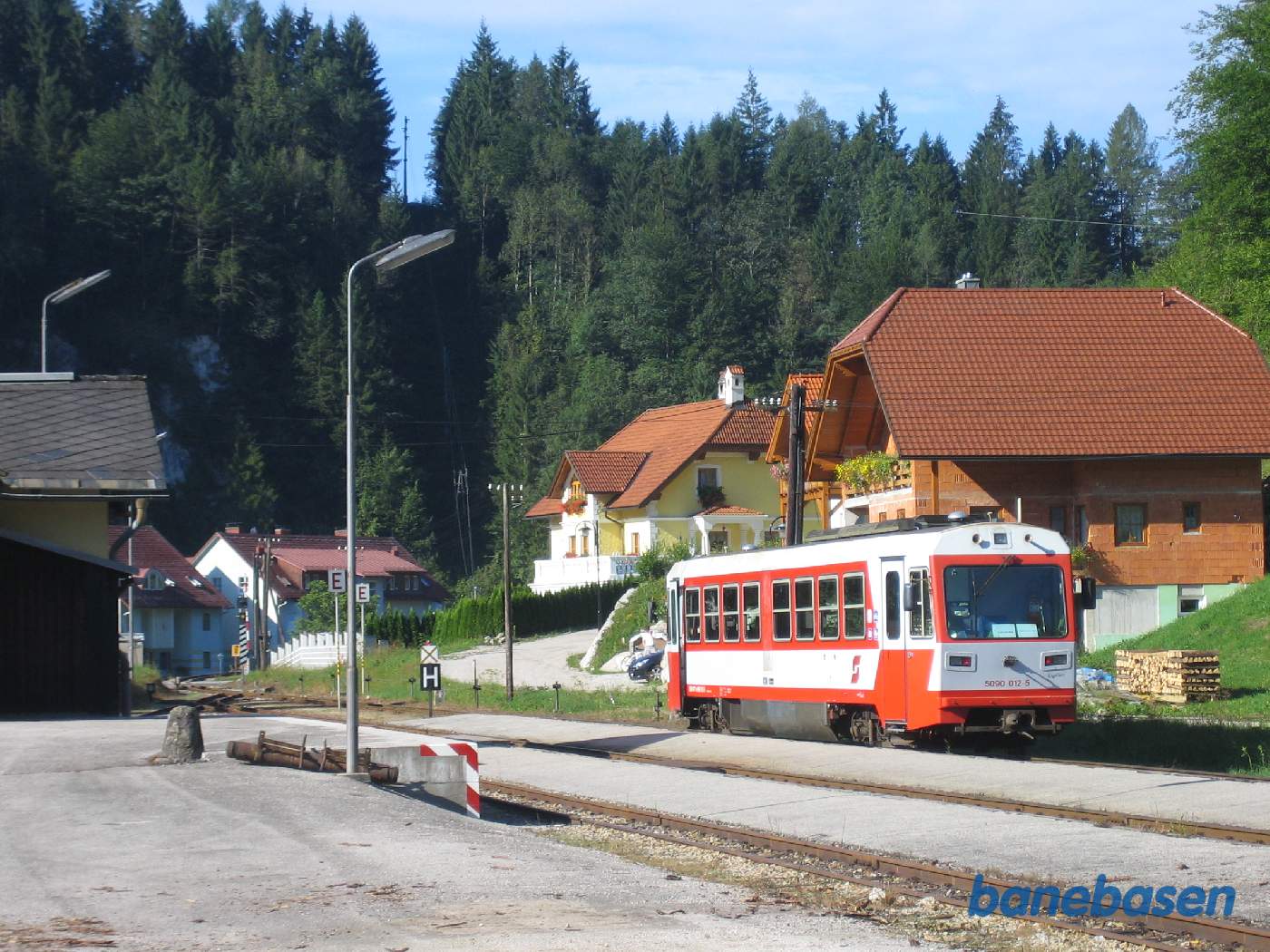 En motorvogn holder på stationen. Stationsbygningen ses til venstre i billedet. Banen fortsætter mod Wieselburg
