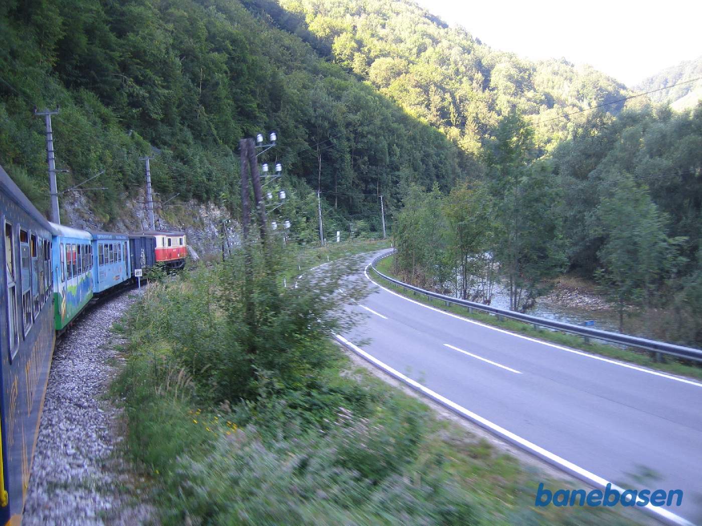 Toget kører langs en vej og en flod