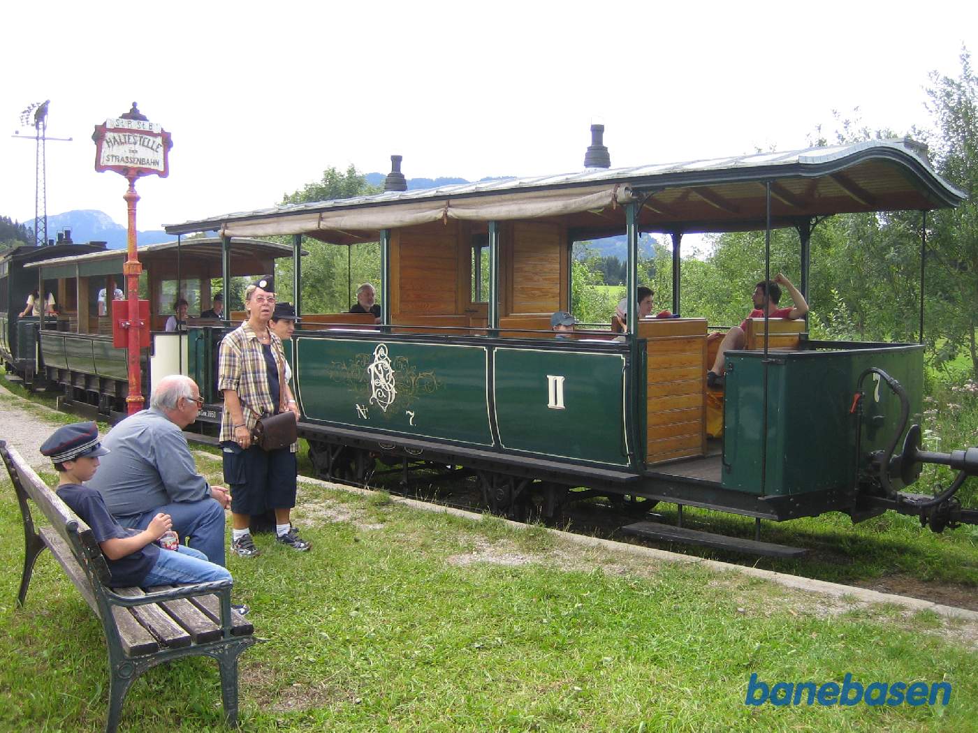 De åbne personvogne efter lokomotivet ved perron