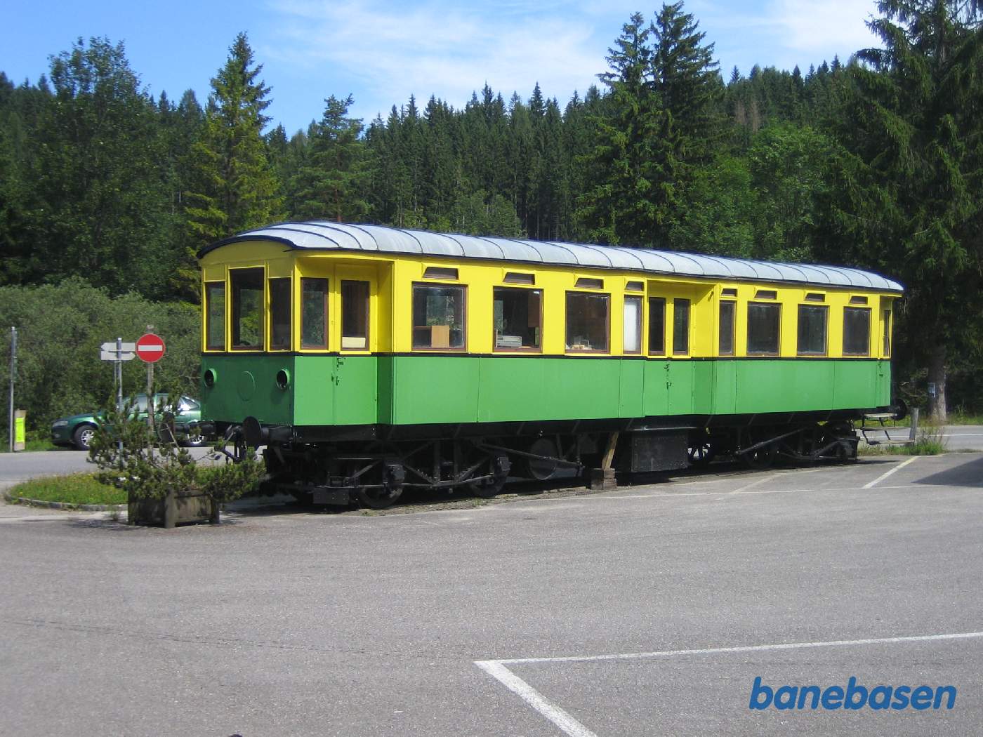 En grøn-gul vogn udstillet på en sporramme