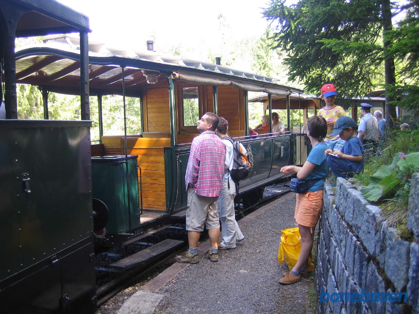 Turister på perronen og persontog ved perron