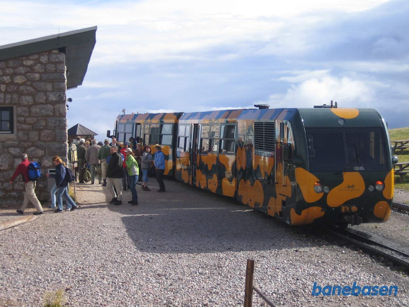 Et persontog er ankommet til stationen og turisterne strømmer ud