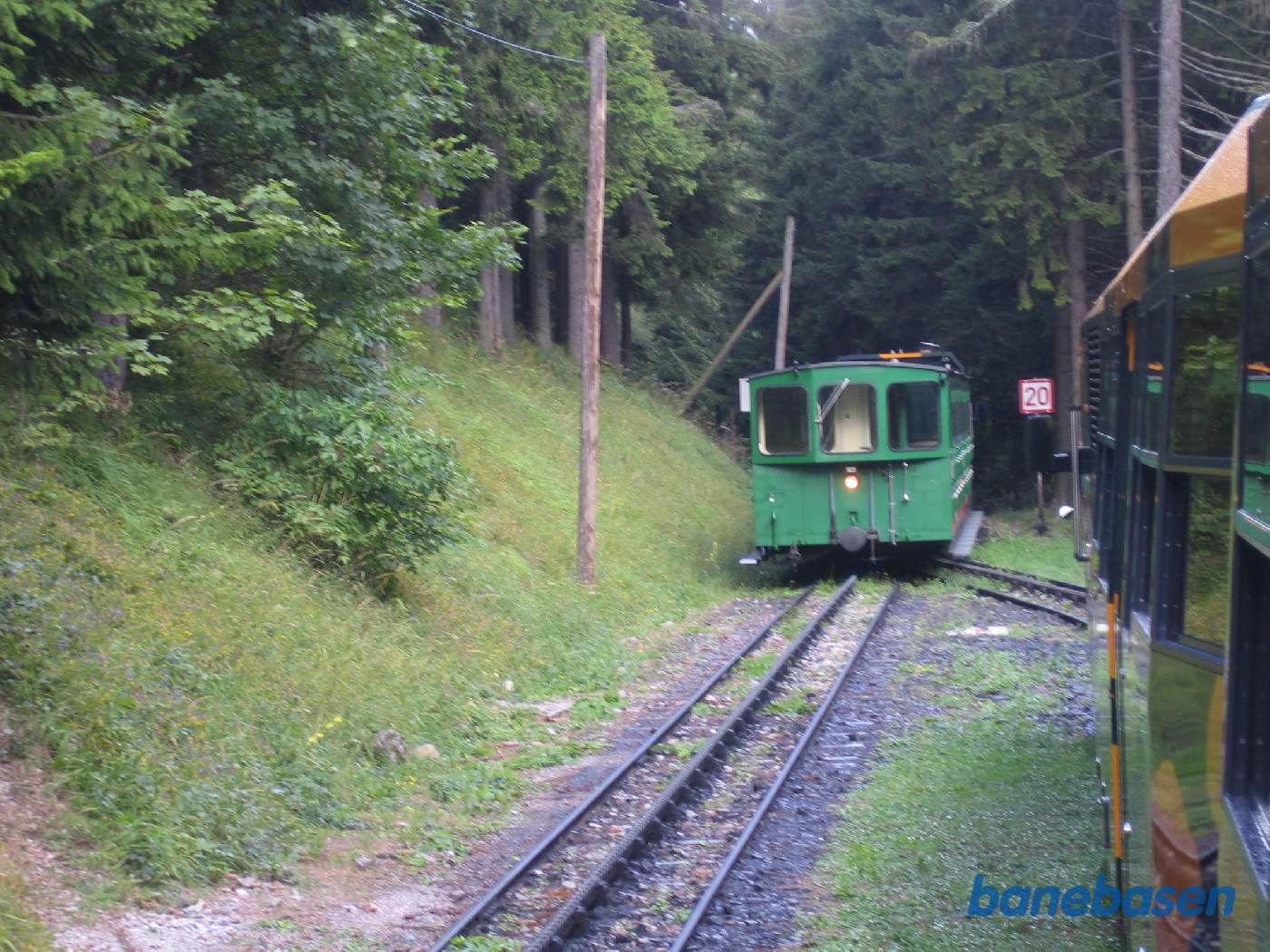 Krydsning med tog på vej op ad bjerget på en teknisk krydsningsstation i skoven