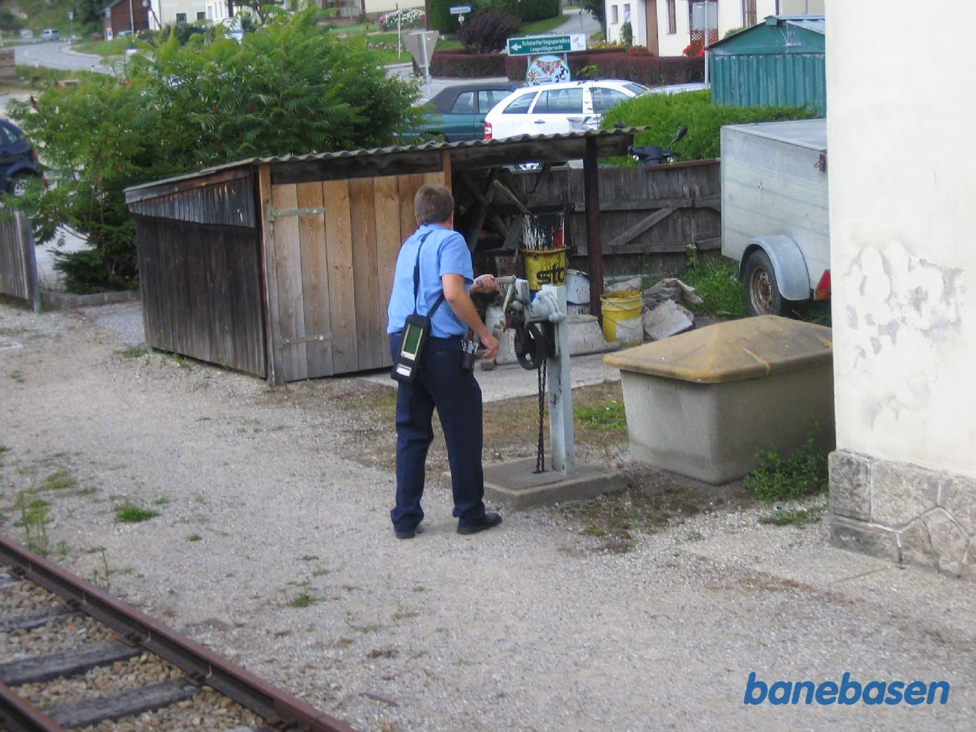 Stationsforstanderen i gang med at rulle bommen over vejen ned