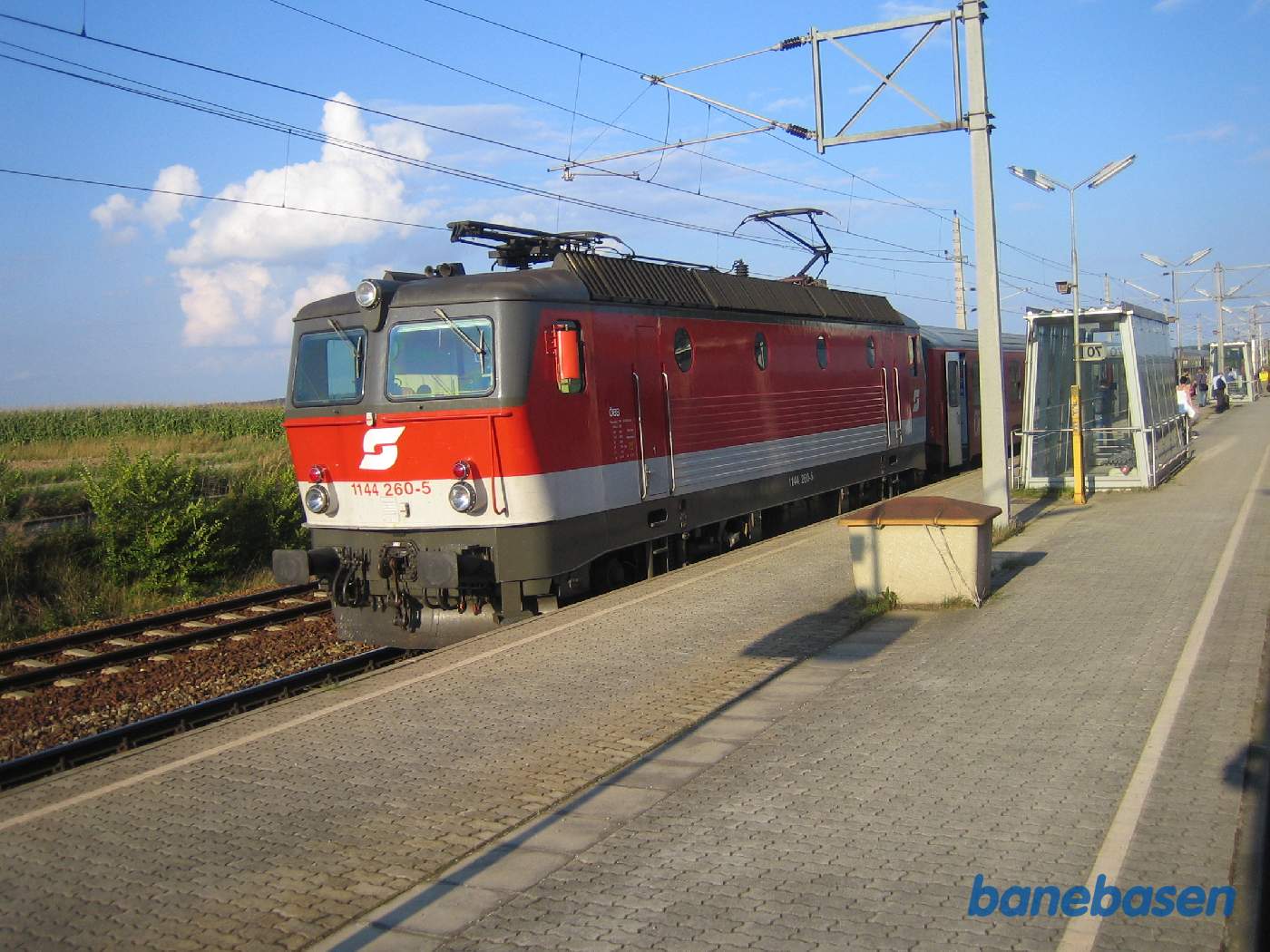 Et persontog ved perron på en østrigsk station, set ud af togvinduet på det modkørende tog