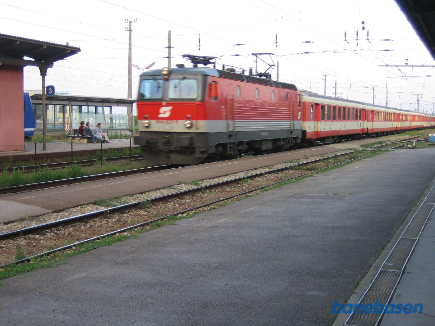 Et persontog fra Wien på vej ind på stationen, man kan lige se snuden af det blå tog i spor 4 der skal til Wien