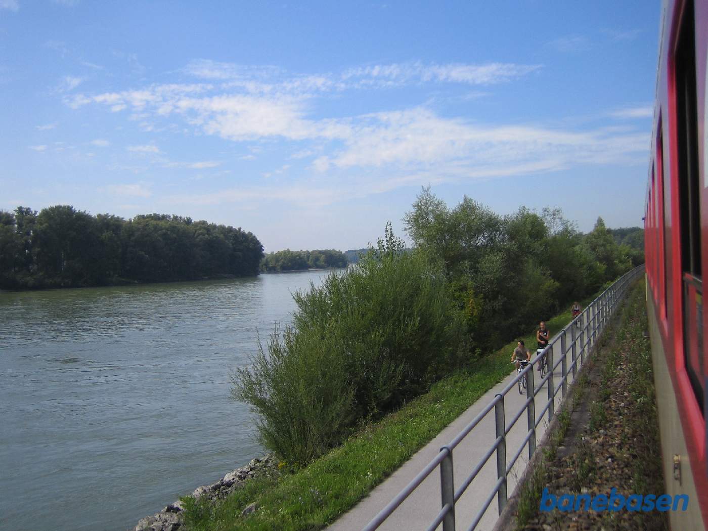 Toget kører langs en cykelsti, Donau til venstre i billedet
