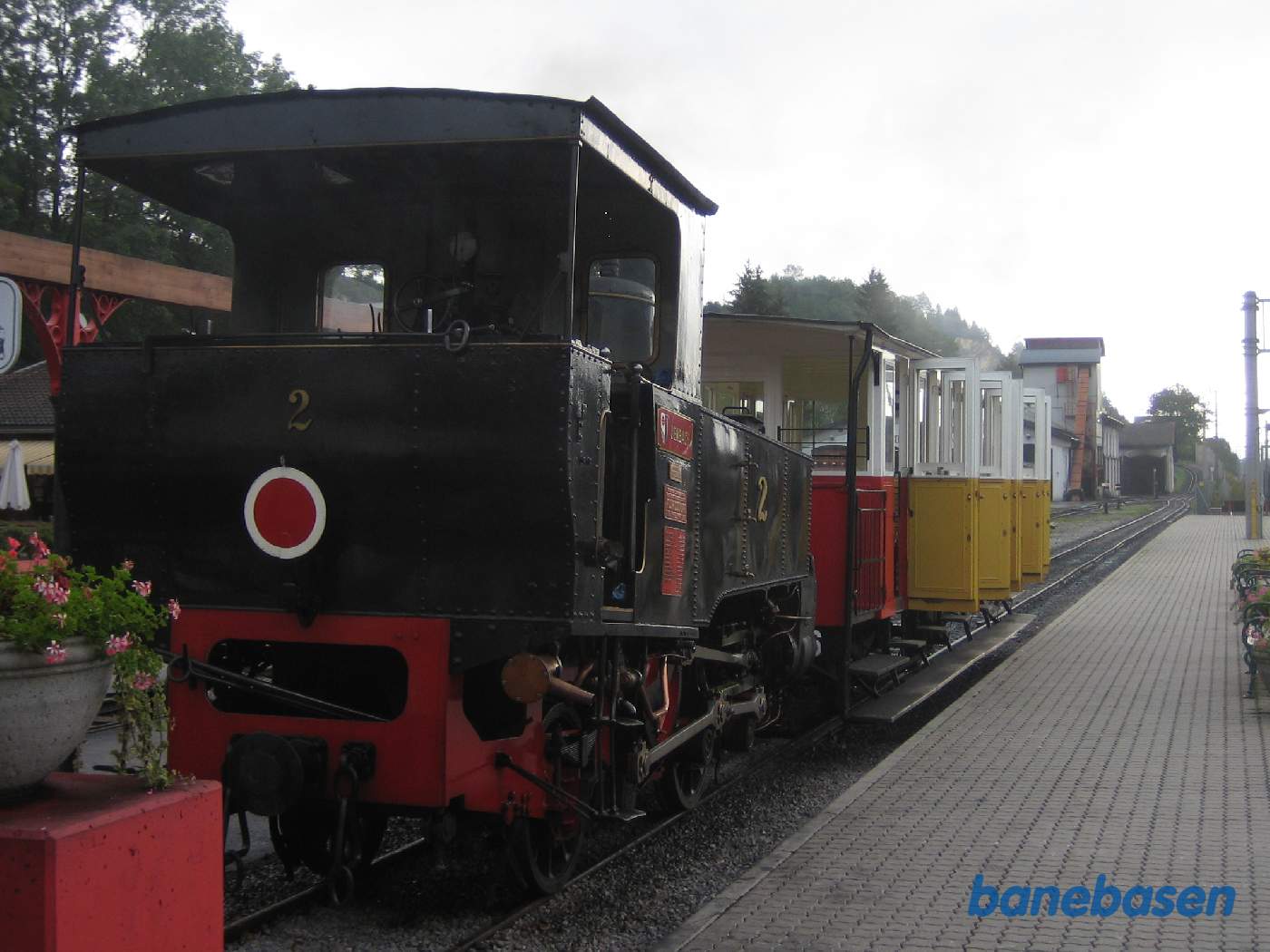 Et tandhjulslokomotiv med en personvogn ved perron