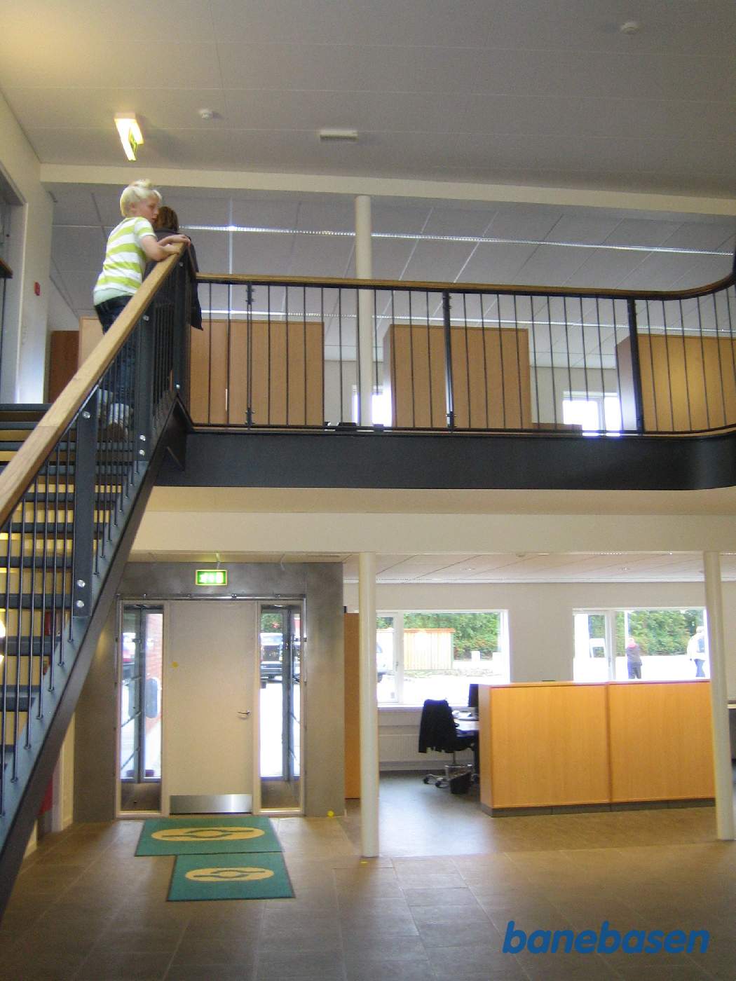 Indgangen til bygningen (den hvide dør), kontoerne og mødelokalerne er placeret under trappen op til 1.sal, receptionen til højre