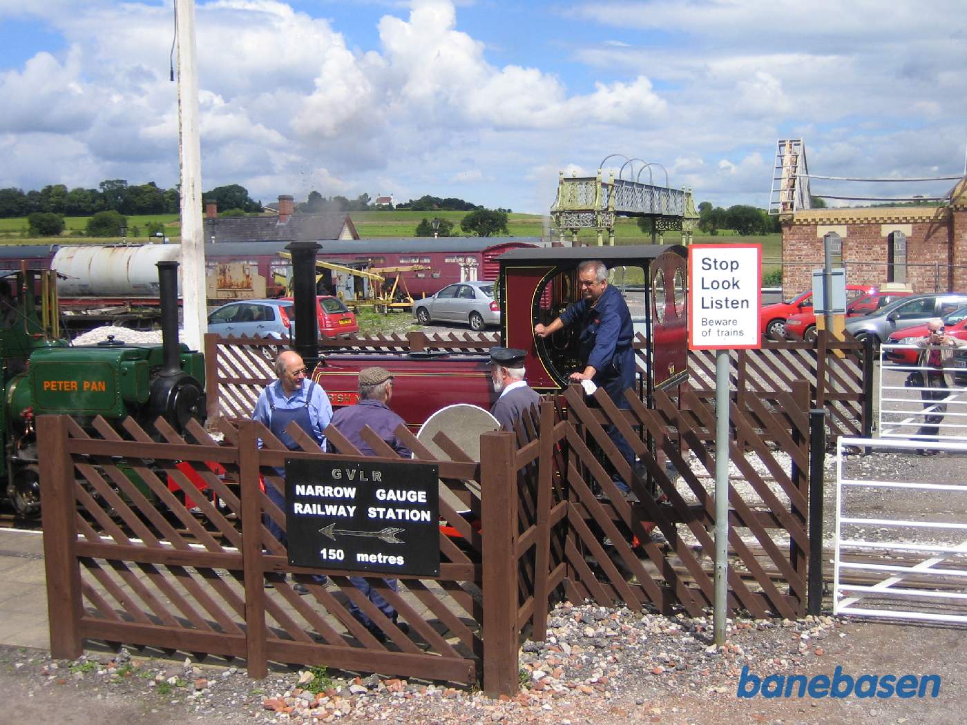 2 damplokomotiver ved overkørslen, det nye værksted udenfor billedet til højre og den nye stationsbygning under opførelse i baggrunden