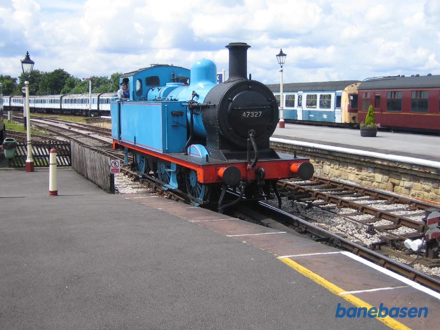 Det blå damplokomotiv triller ned mod vognene