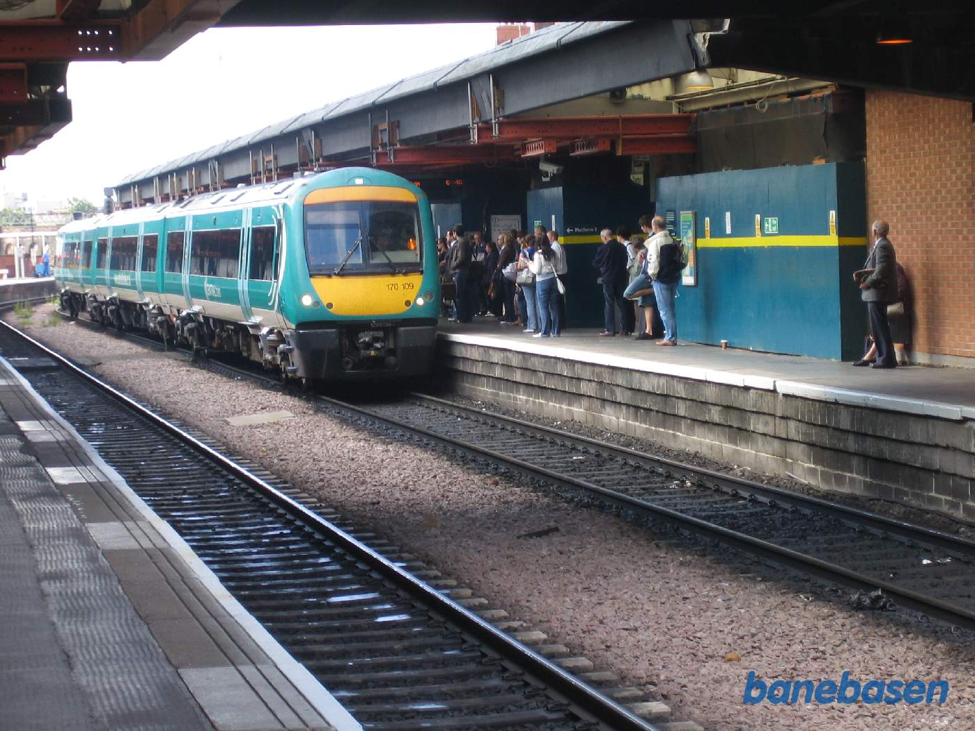 Et persontog ved perron, mange rejsende