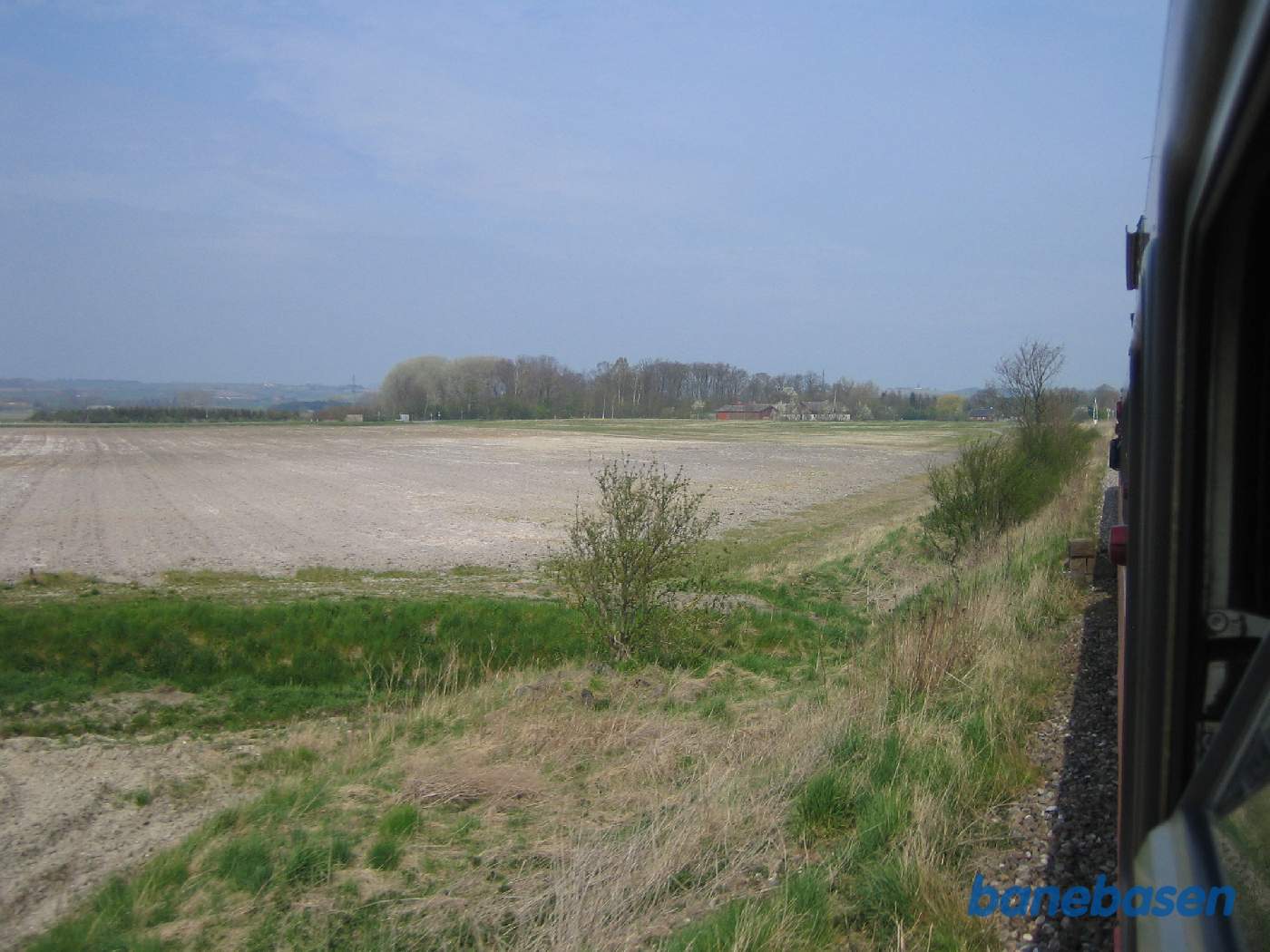 Foto af landskabet på strækningen mellem Asnæs og Fårevejle. Overkørsel længere fremme