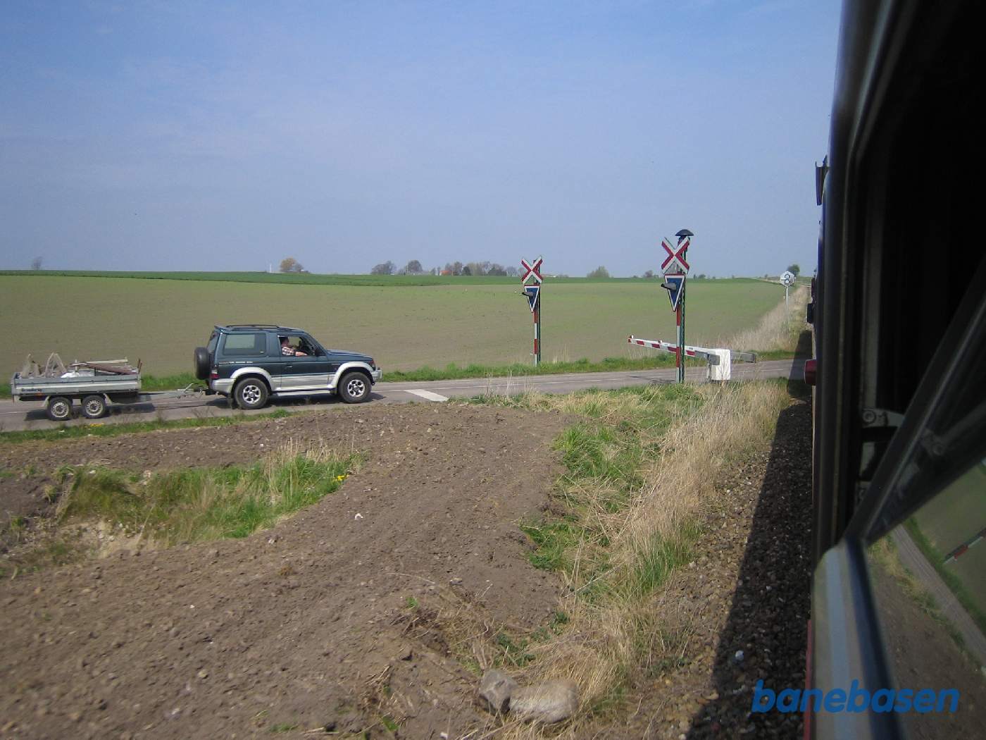 Foto af landskabet på strækningen mellem Fårevejle og Svinninge. Overkørsel lige fremme