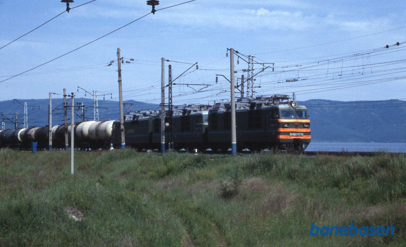 Et godstog med tankvogne. Baikalsøens blå vand til højre bag toget