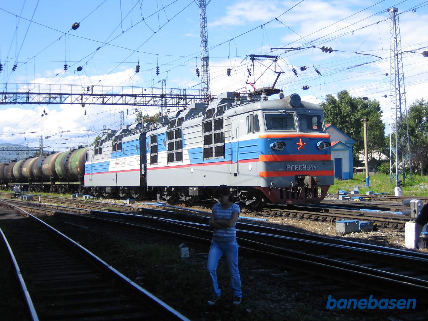 En ung dame foran et stort godstogslokomotiv