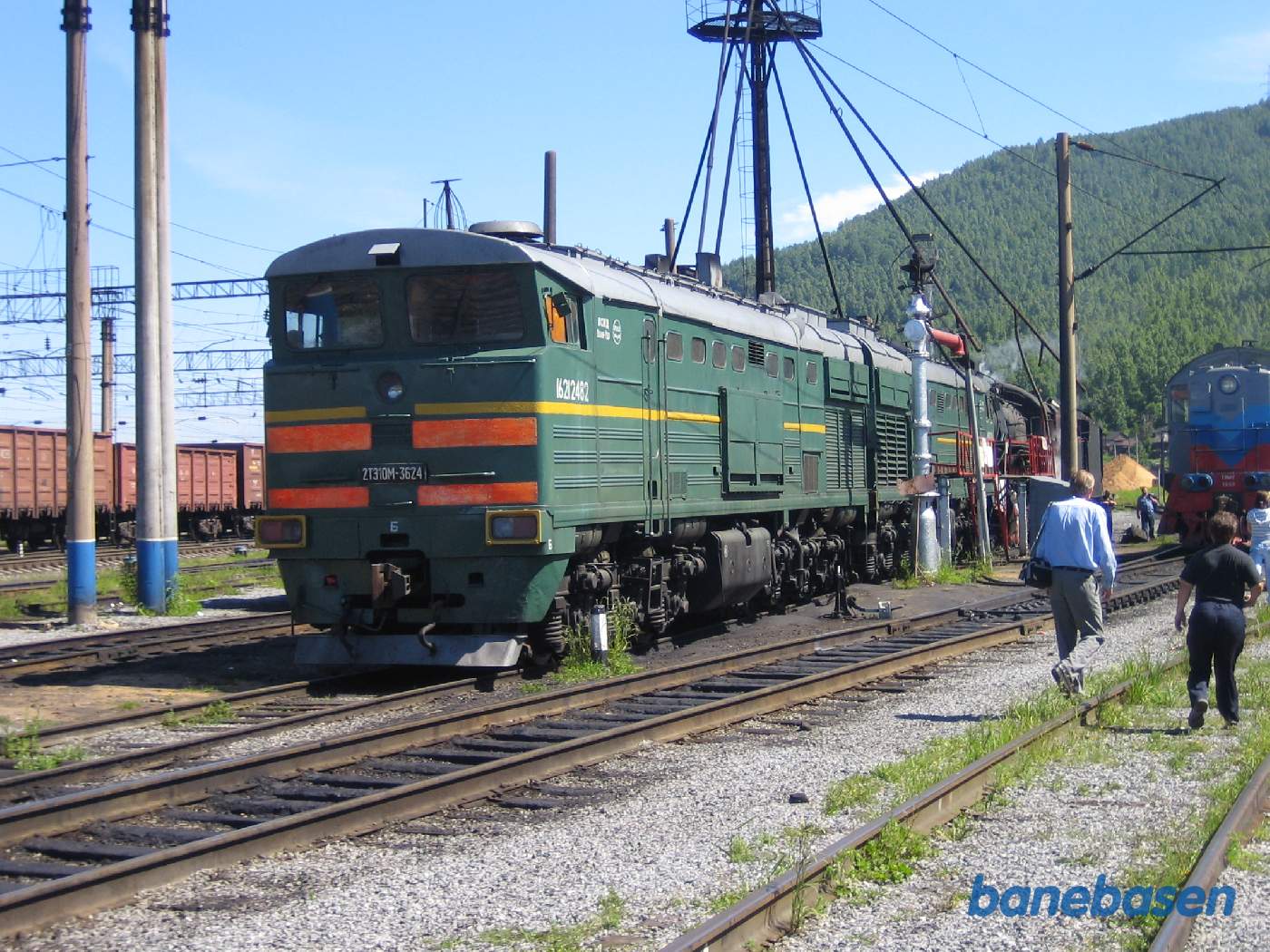 Turister på jernbaneområdet på vej ud til 2 damplokomotiver