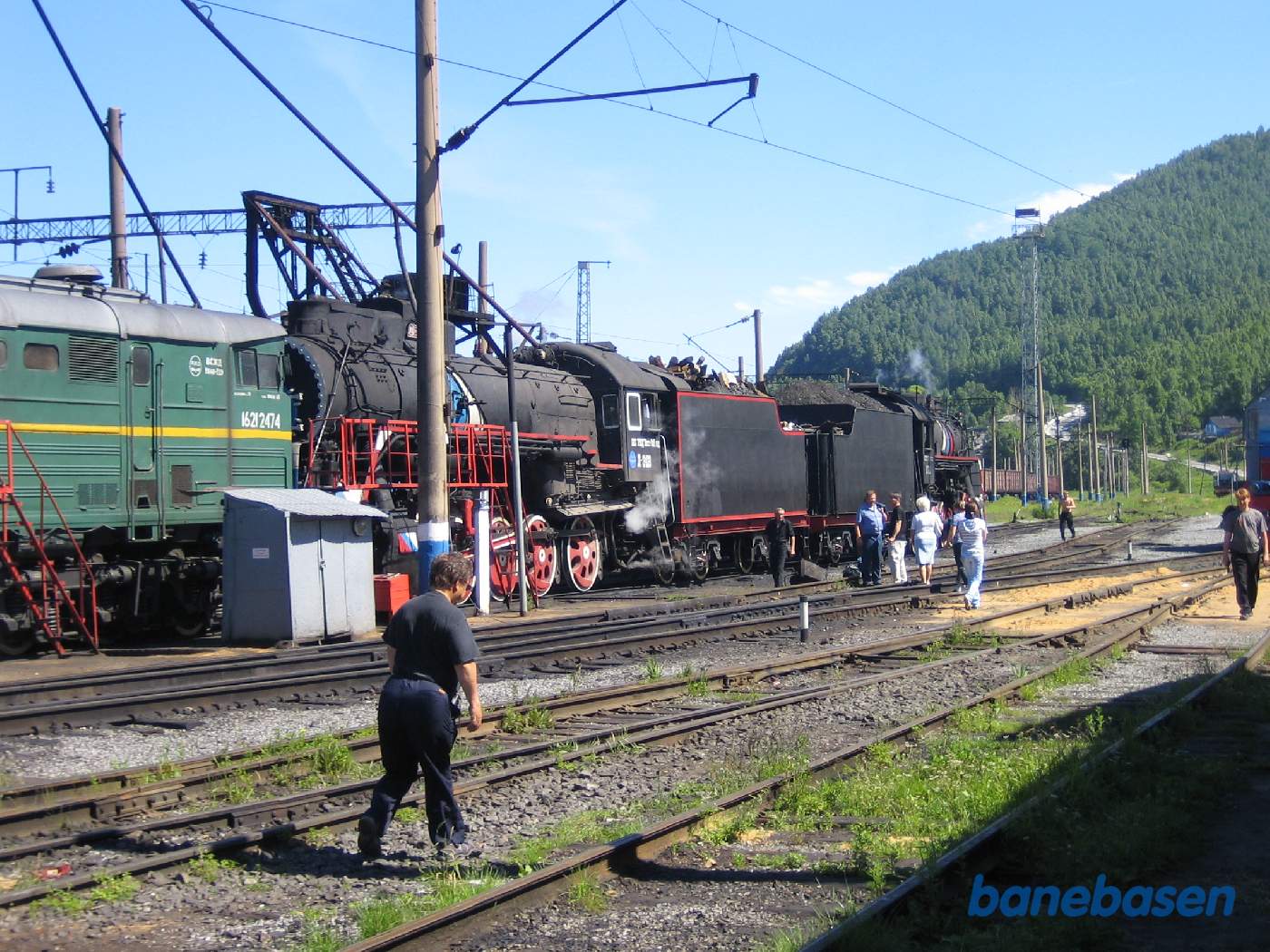 Turister på jernbaneområdet på vej ud til 2 damplokomotiver