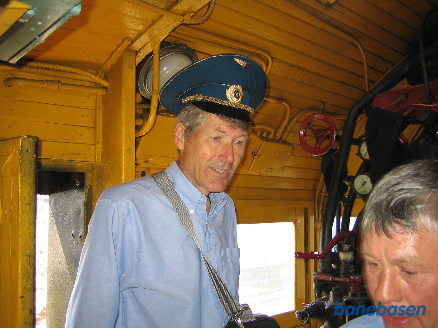 Nærbillede af førerhuset. En turist med kasket