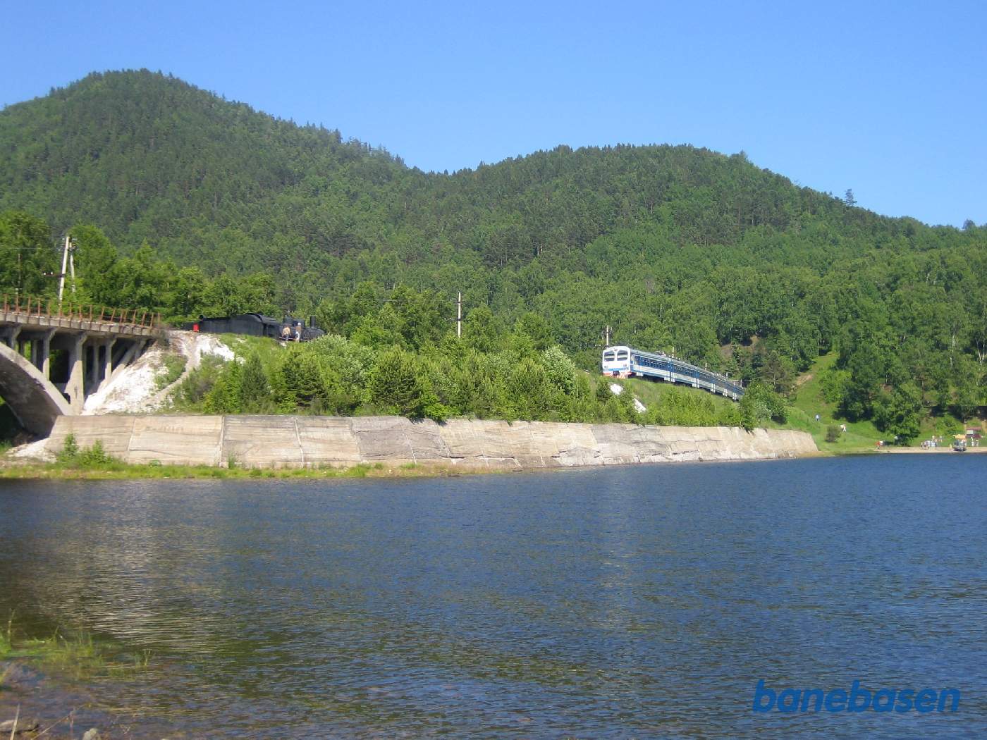 Persontoget ses oppe på trinbrættet og damplokomotivet til venstre