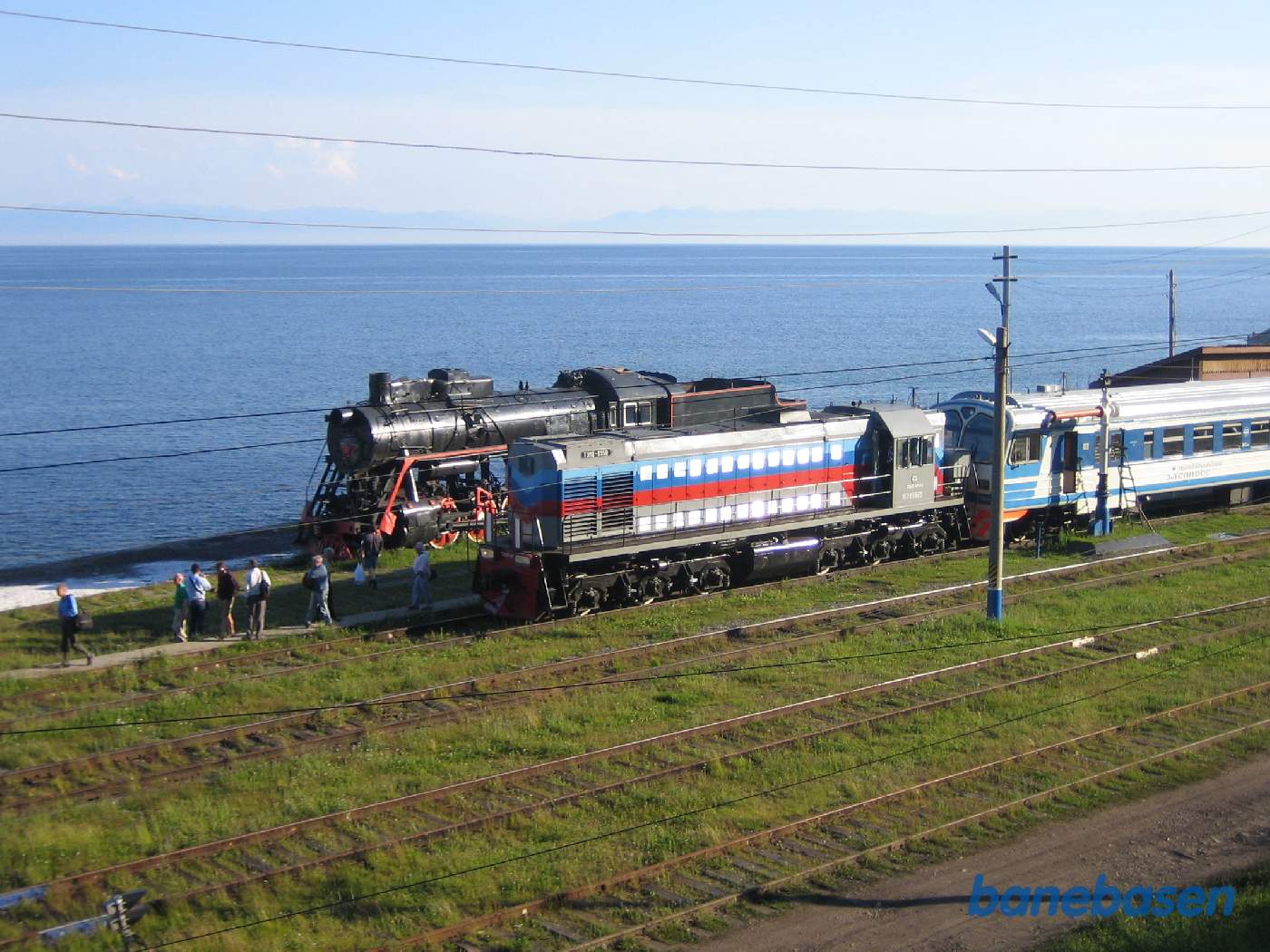 Persontoget ved perron og søens blå vand i baggrunden