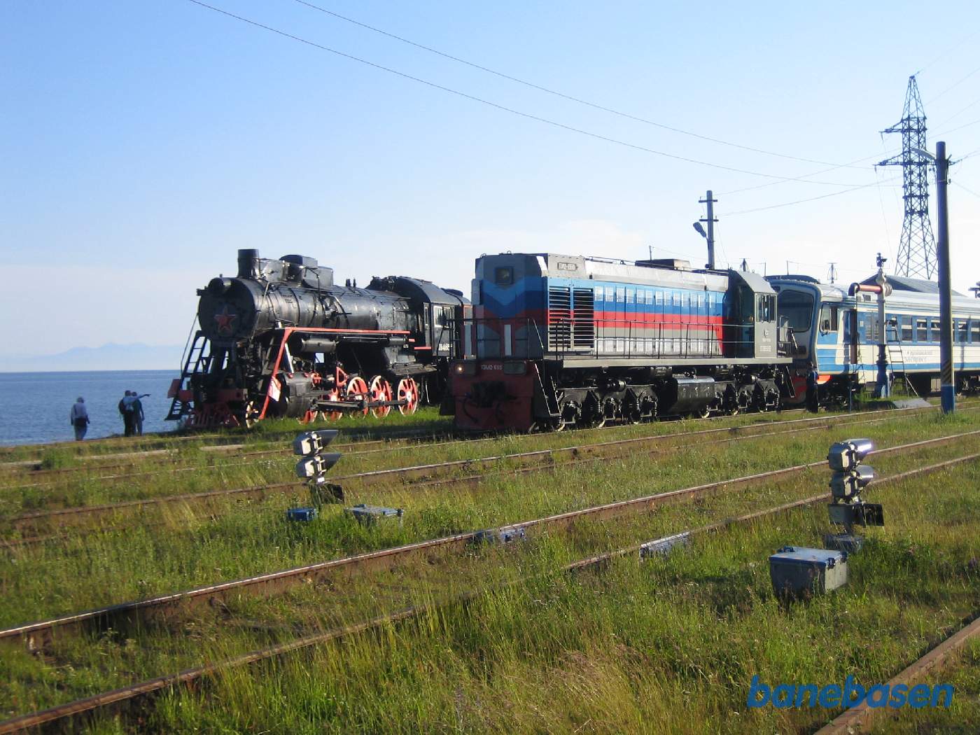 Persontoget ved perron og søens blå vand i baggrunden