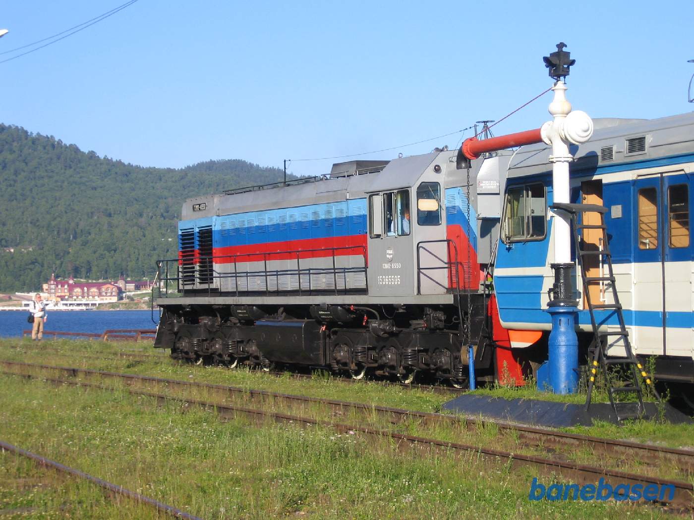 Persontoget ved perron og søens blå vand i baggrunden. Det er søens eneste udløb gennem Angara floden