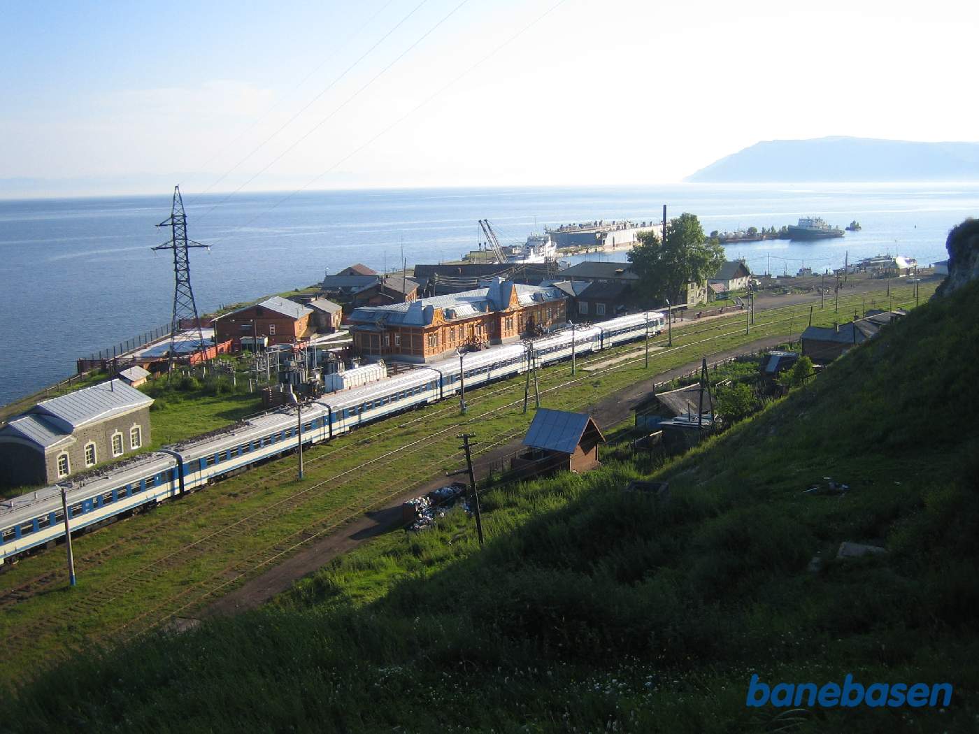 Stationen set oppe fra den stejle skråning. Det lange persontog ved perron og stationsbygningen ses midt i billedet