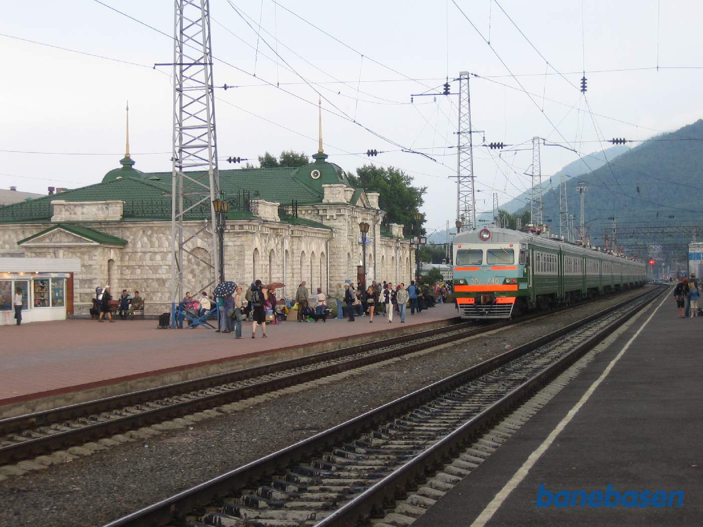 Et persontog ved perron, den hvide marmor stationsbygning til venstre