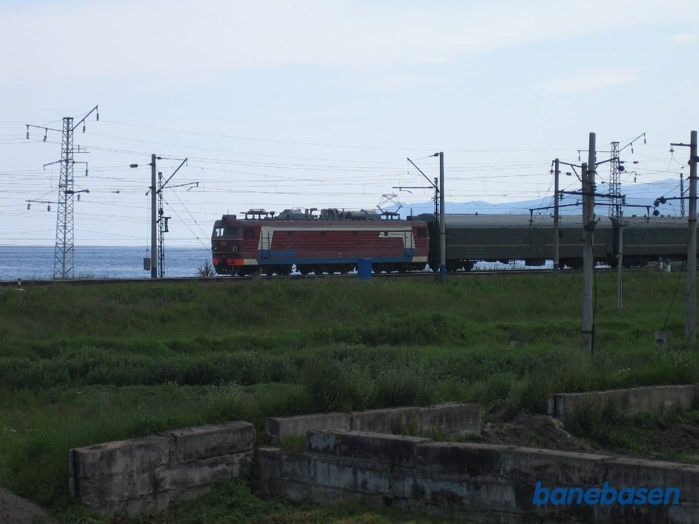 Et persontog på vej mod Moskva har netop forladt stationen, Baikalsøen i baggrunden