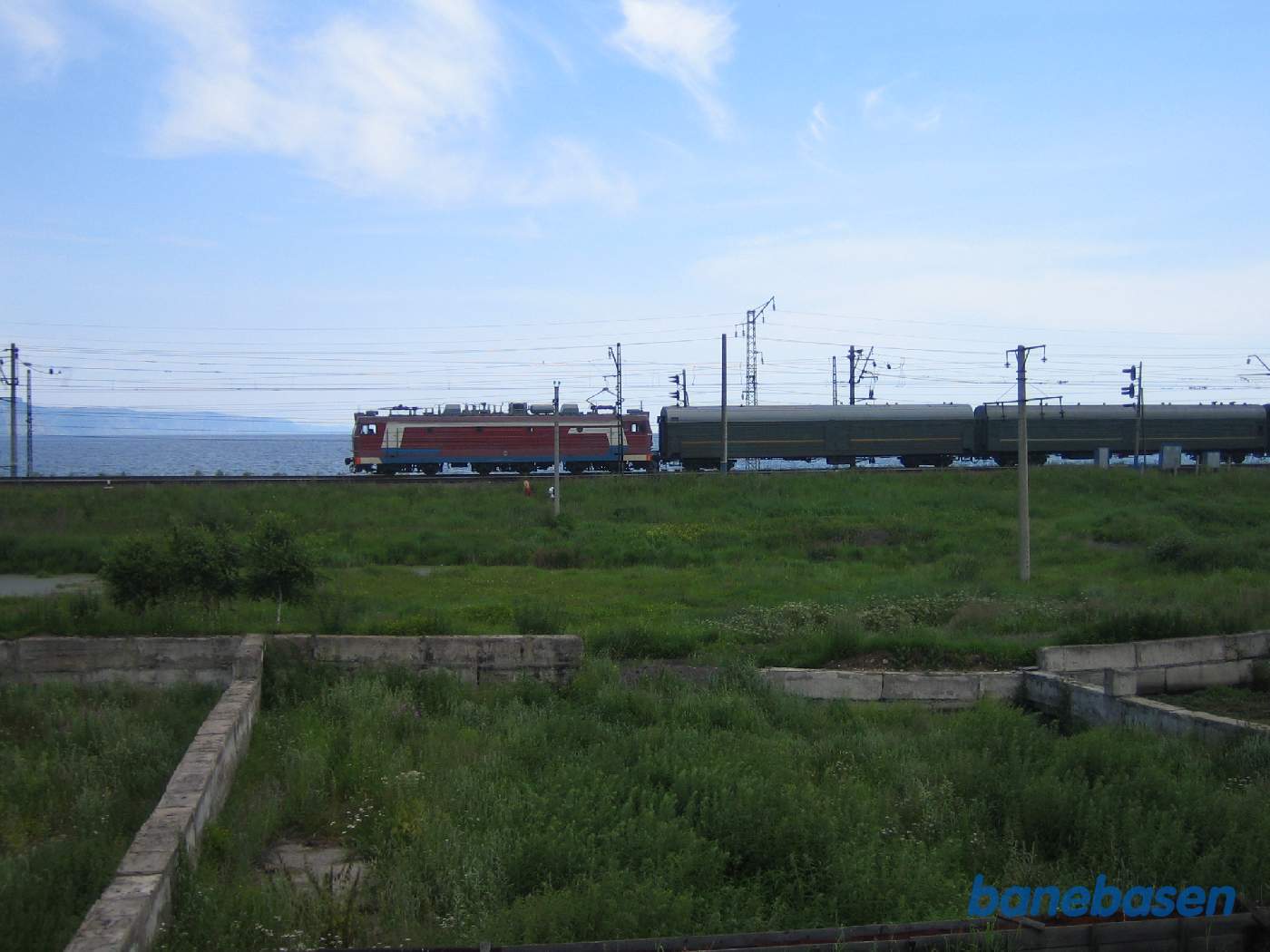 Et persontog på vej mod Moskva har netop forladt stationen, Baikalsøen i baggrunden