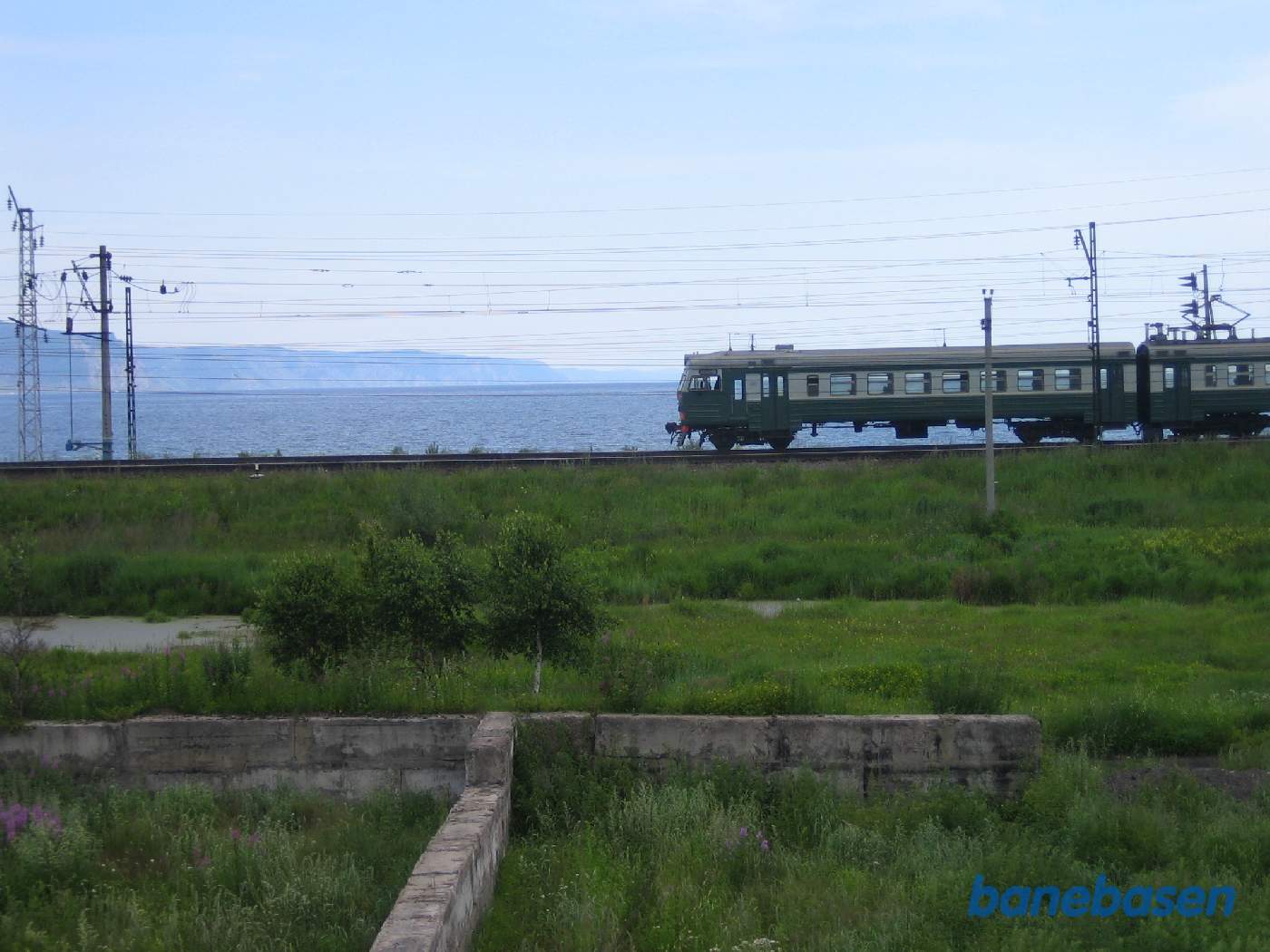 Et persontog på vej mod Irkutsk har netop forladt stationen, Baikalsøen i baggrunden