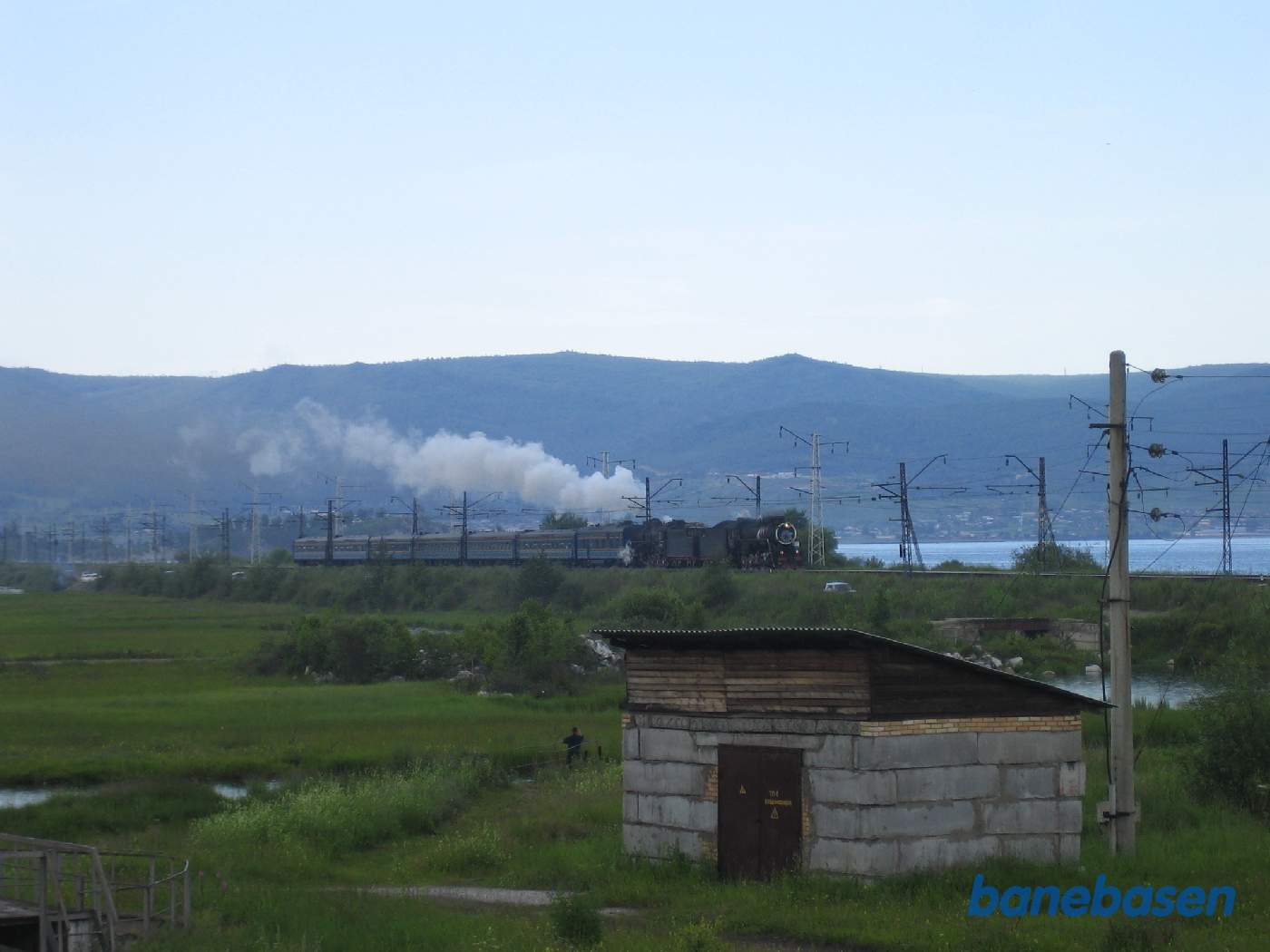Et turisttog med 2 damplokomotiver fra Port Baikal på vej ind mod Sludyanka station, Baikal søen til højre