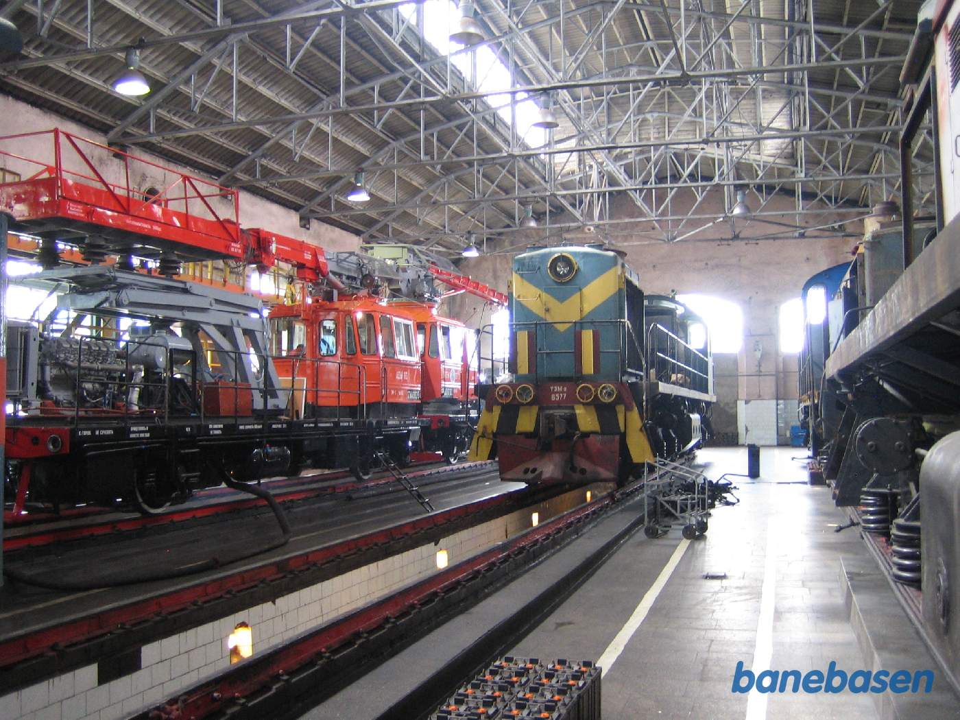 Et diesel lokomotiv inde i værkstedet og et arbejdskøretøj i det andet spor