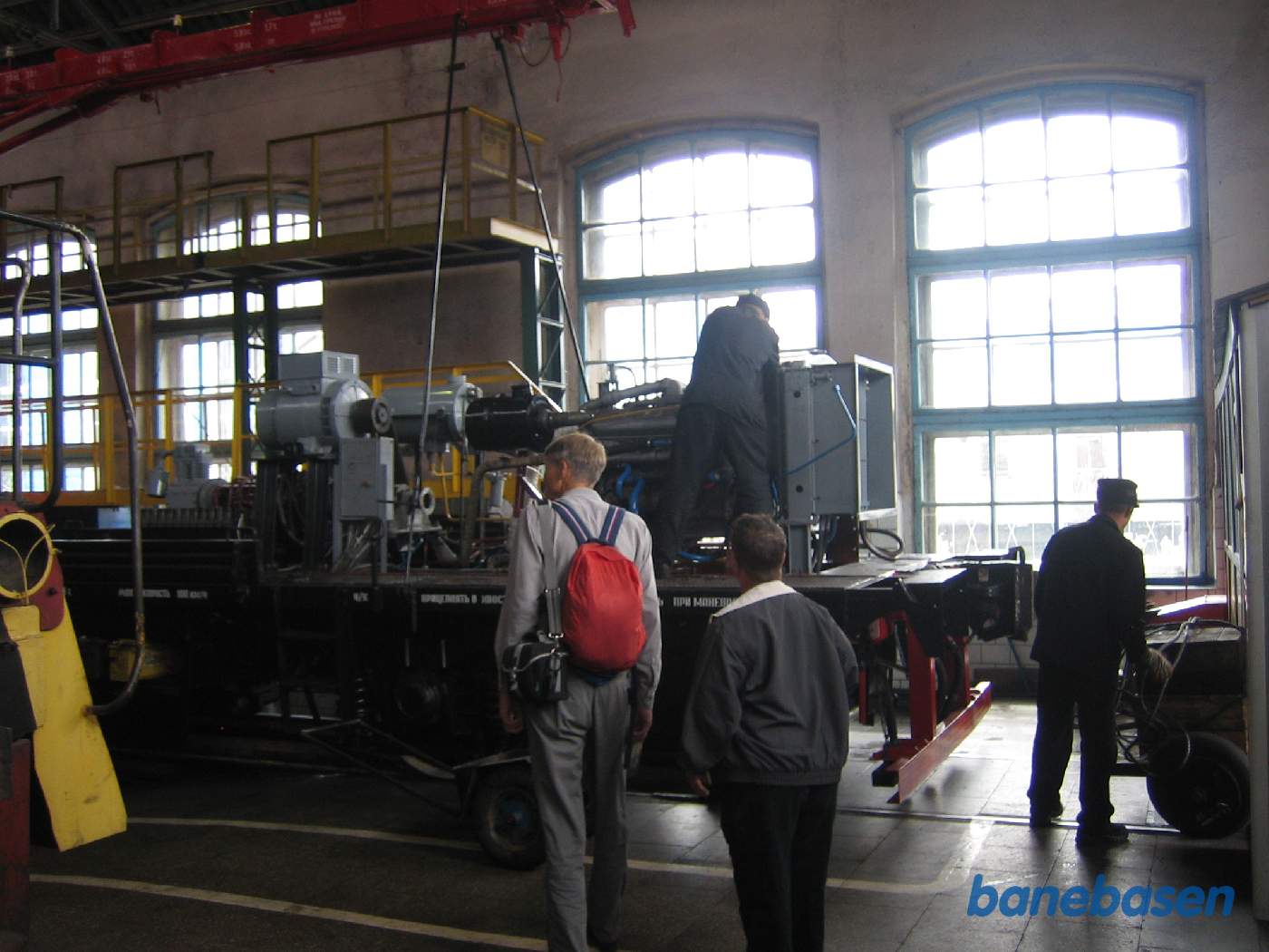 2 gæster foran et adskilt jernbanekøretøj, som der arbejdes på