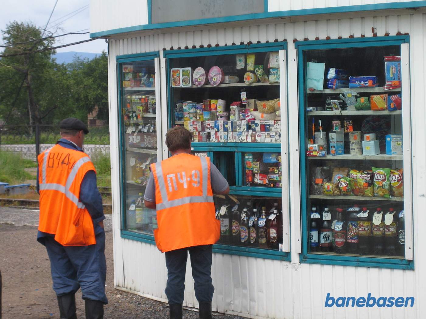 2 banearbejdere handler i den lille kiosk på perronen