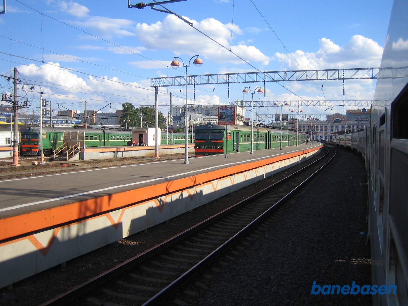 Toget triller langsomt til perron, 2 andre persontog ved de andre perroner