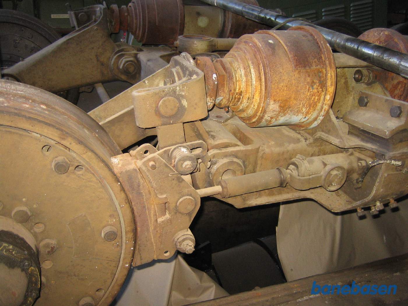 Nærbillede af en løbebogie med affjedring og bremsecylinder og bremseklods