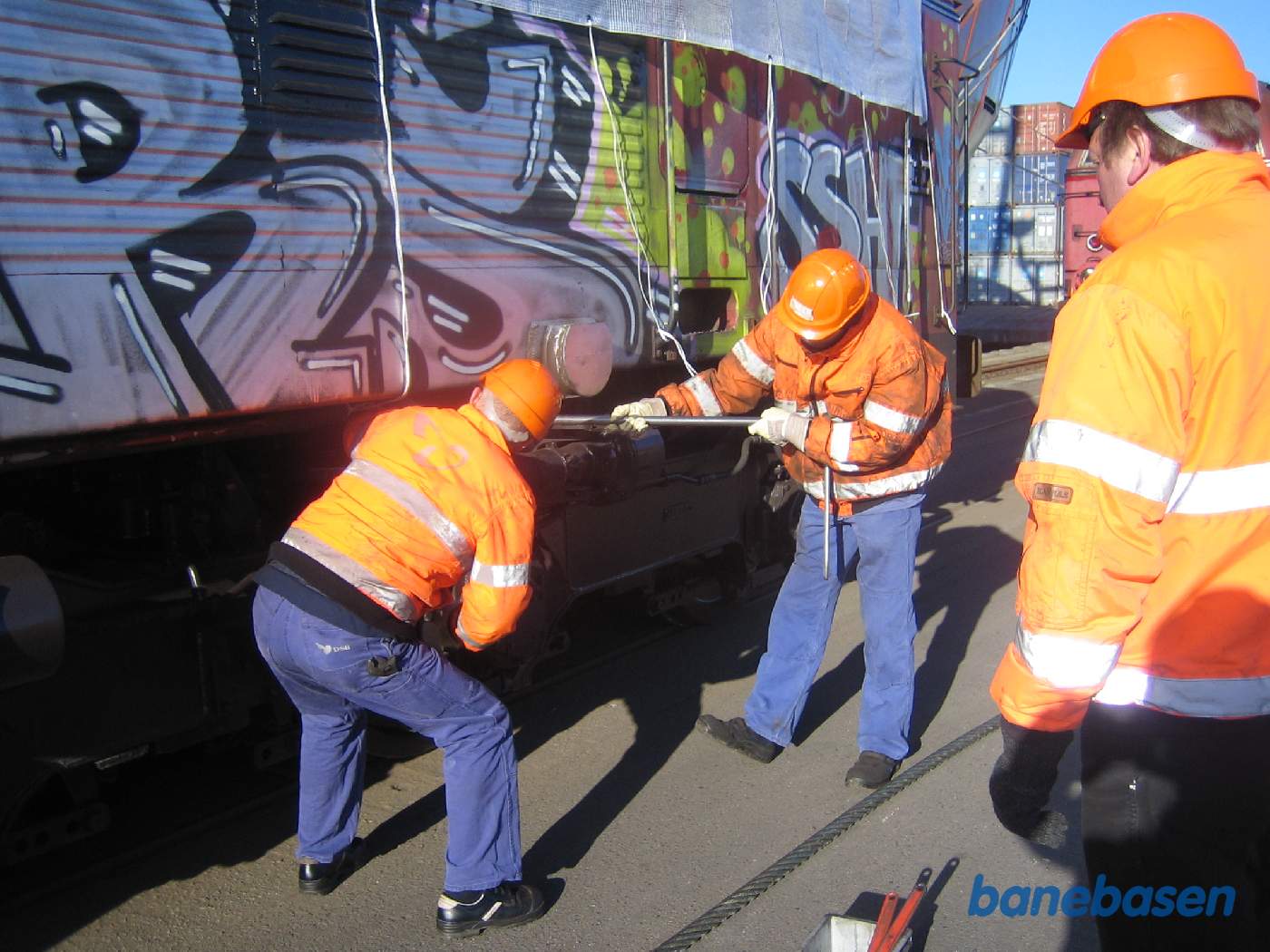 Inden at vognkassen kan løftes ombord, skal den frigøres af bogierne, da kranen ikke også kan løfte bogierne med