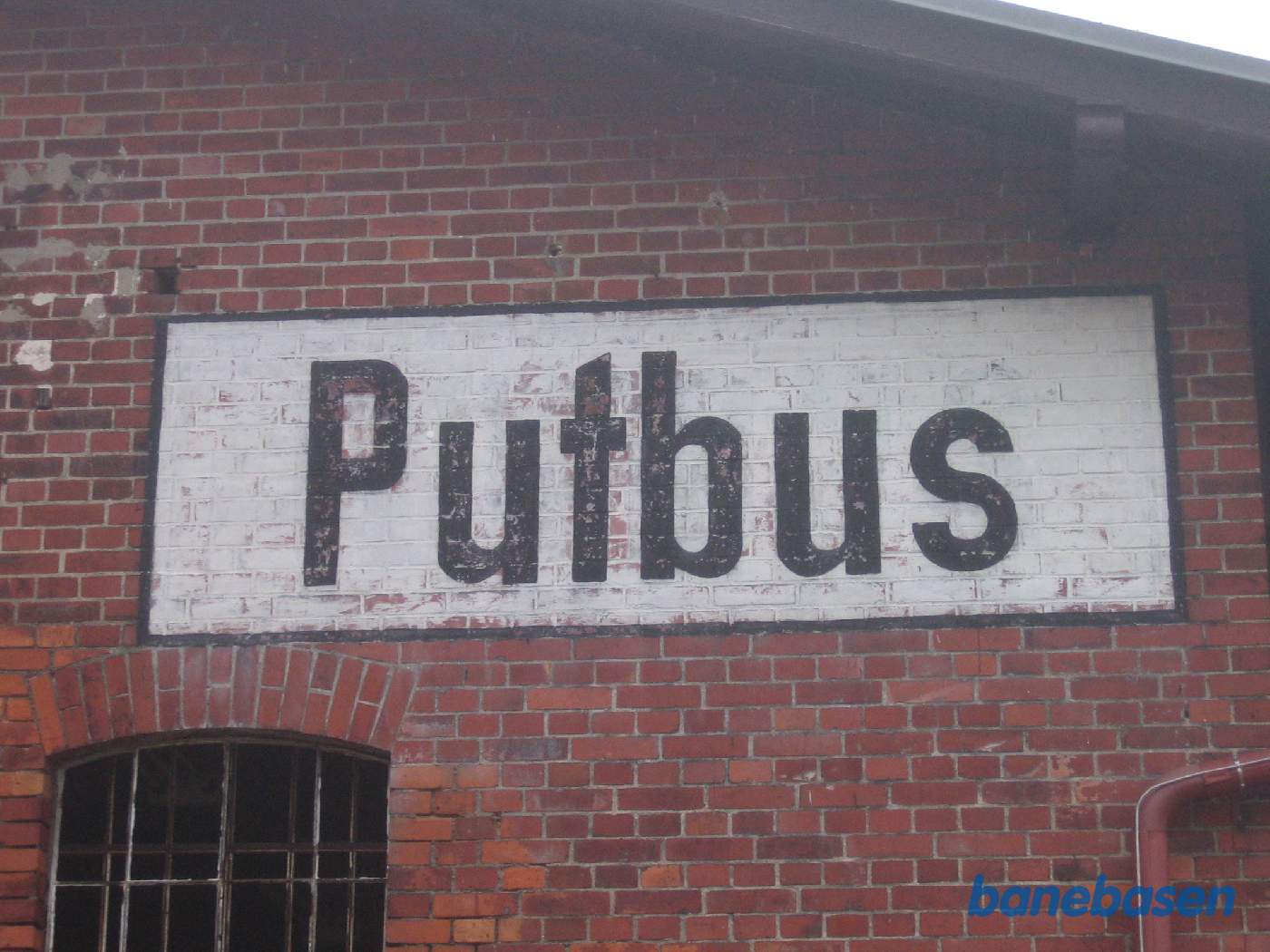 "Putbus" malet på en murstensbygning