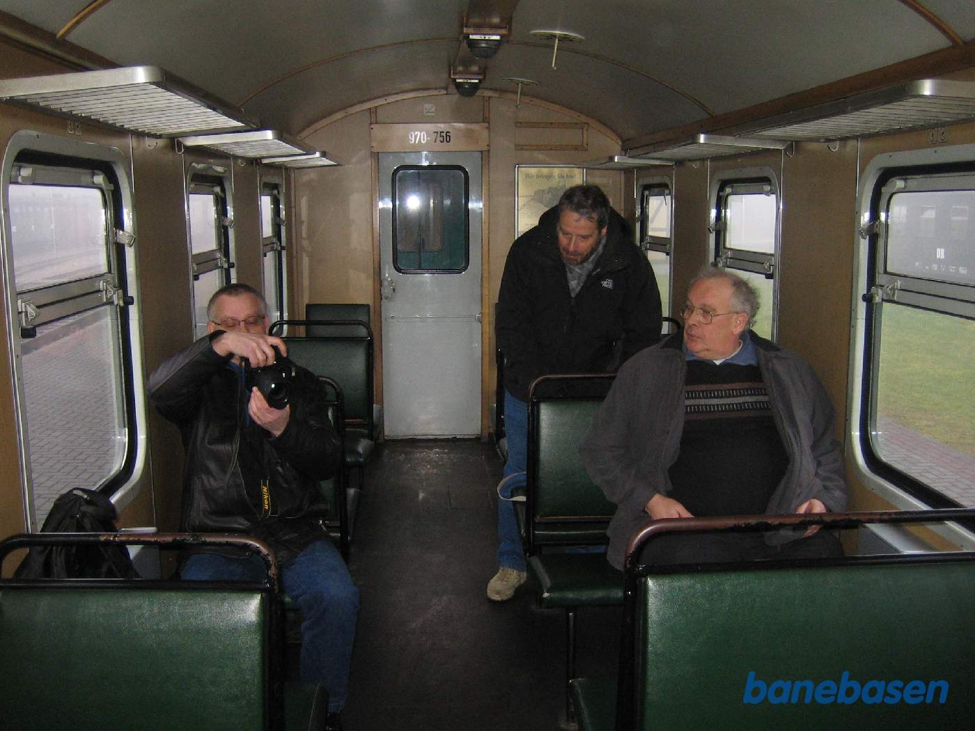 3 turister sidder i en af personvognene, set indefra