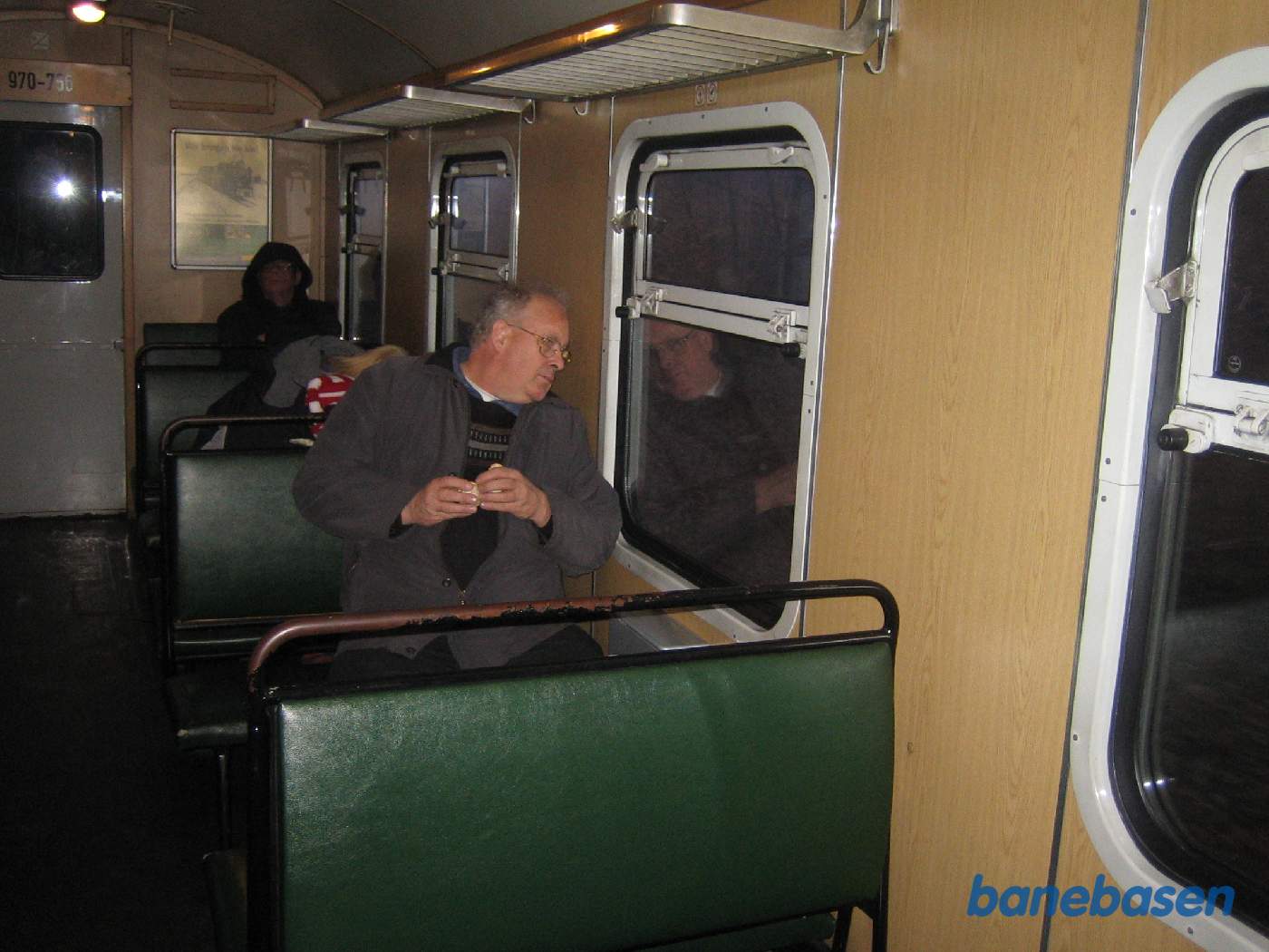 Selvom at det er blevet mørkt udenfor, så kigger en turist alligevel ud af vinduet