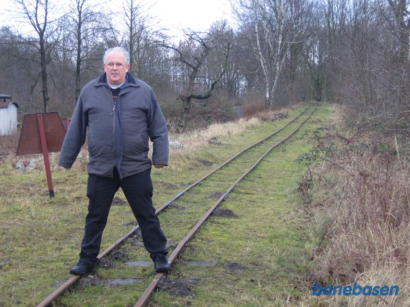 En turist står på de 2 skinnestrenge for at vise, hvor smalt sporet er