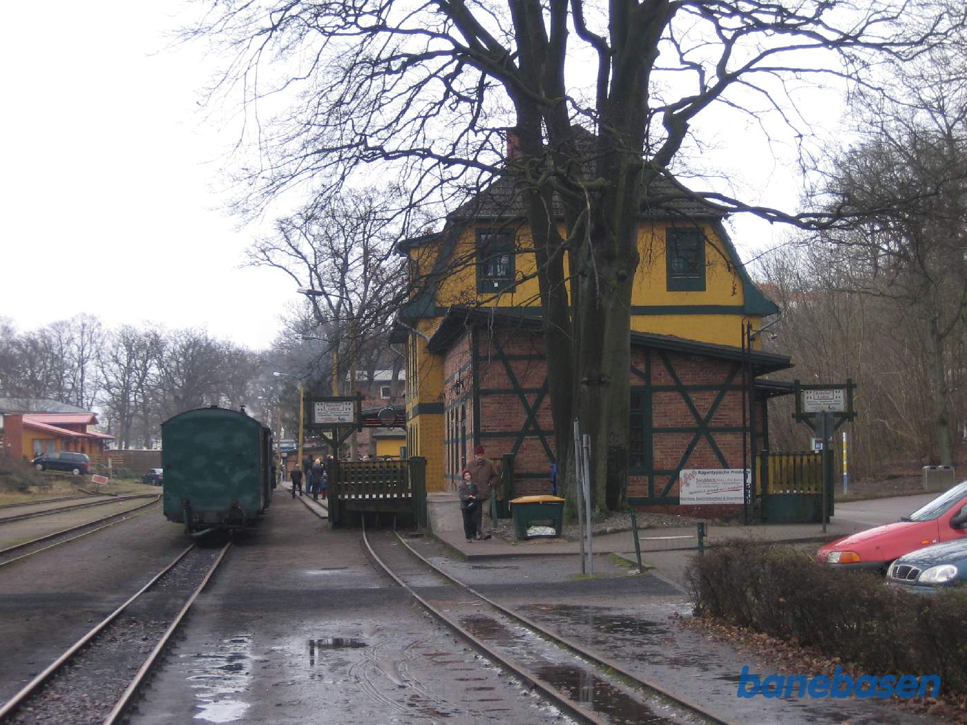 Stationsbygningen set fra indkørslen til stationen, persontoget holder ved perron