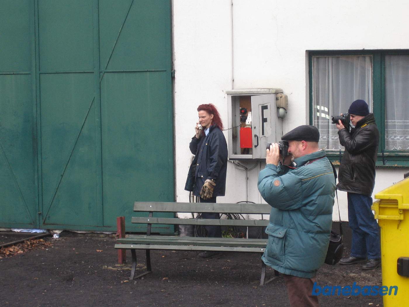 Togføreren taler i telefon på perronen mens fotograferne har travlt