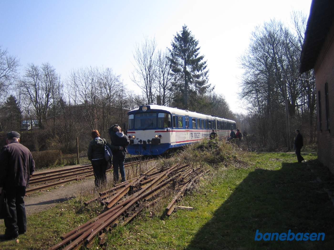 Et Y-tog triller langsomt forbi remisen mens gæsterne ser på